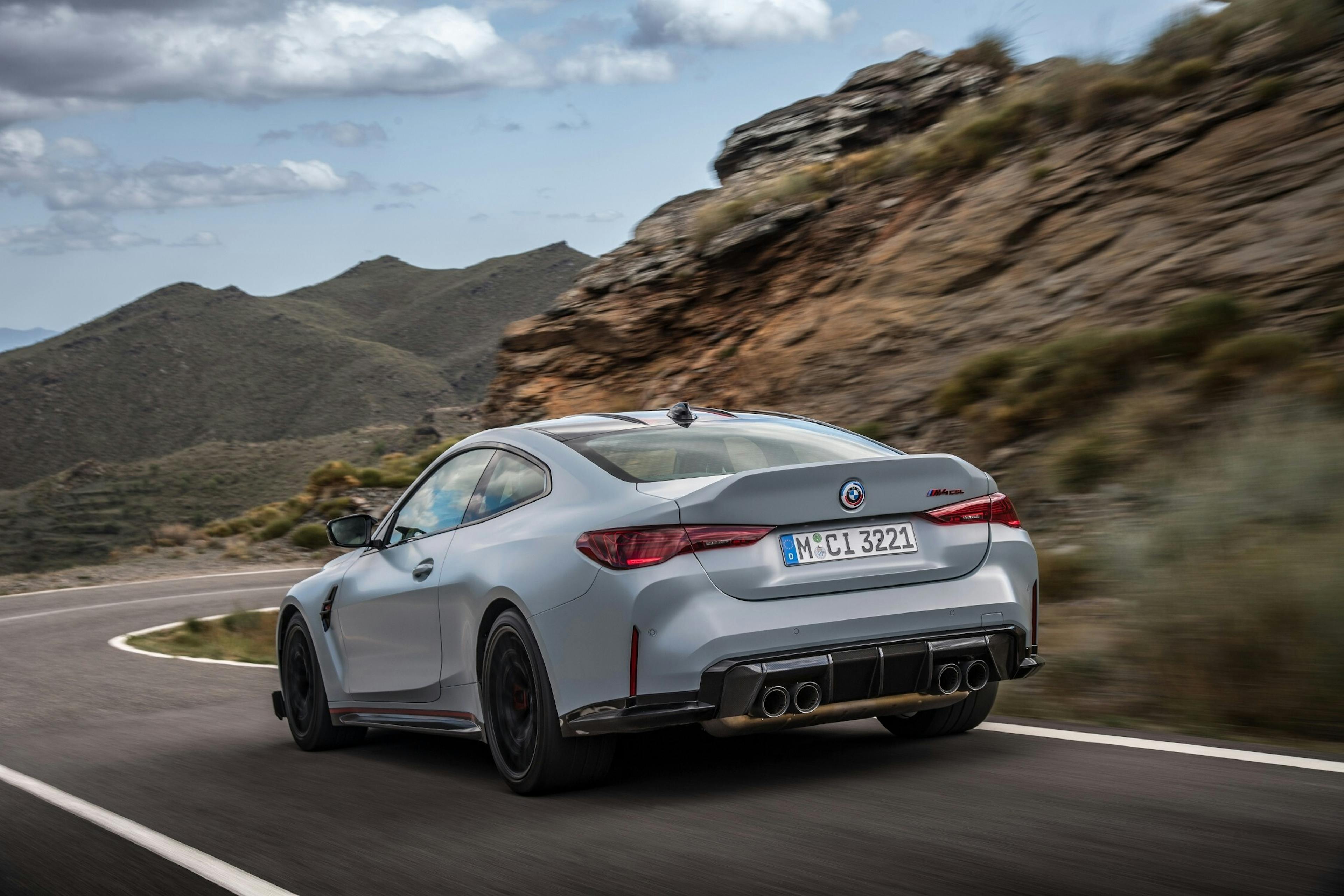 Ein grauer BMW M4 CSL fährt über eine Bergstraße.