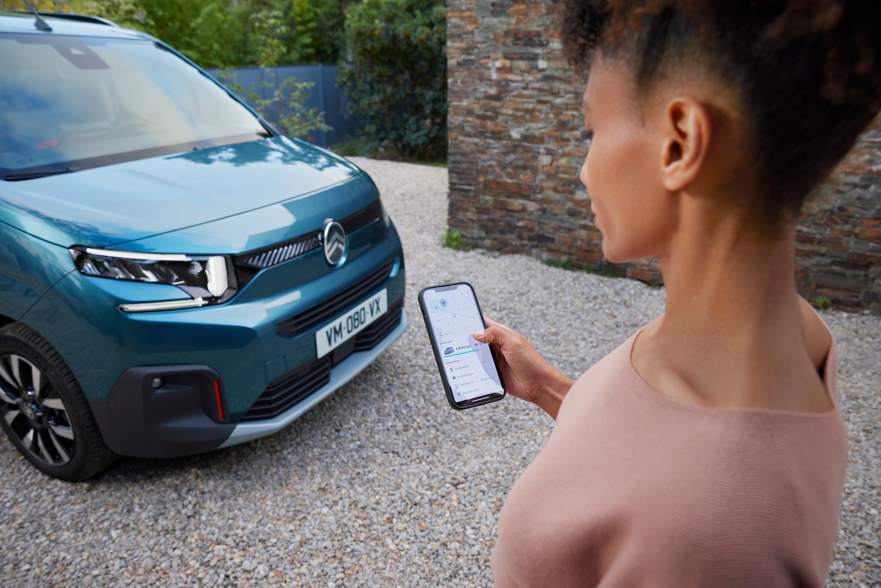 Eine Frau steht vor einem Citroen e-Berlingo