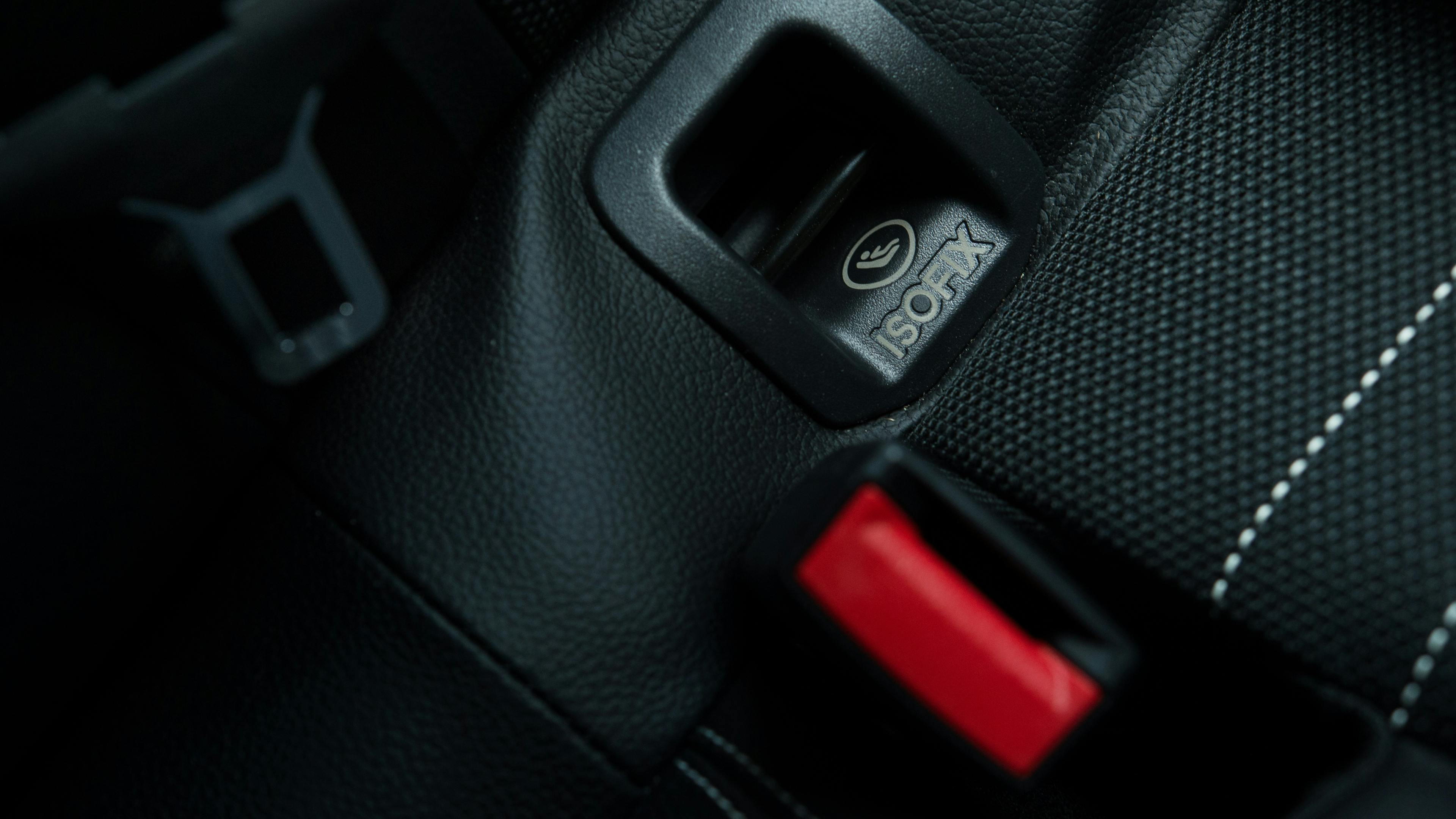 Close-up of an Isofix anchor point on the back seat of a car, which is used to securely attach child seats.