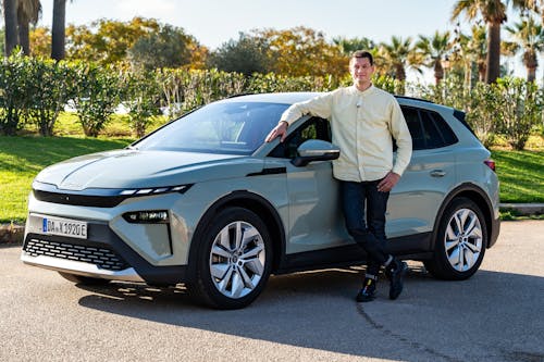 Weißgrauer Škoda Elroq mit einem Redakteur neben dem Auto stehend.