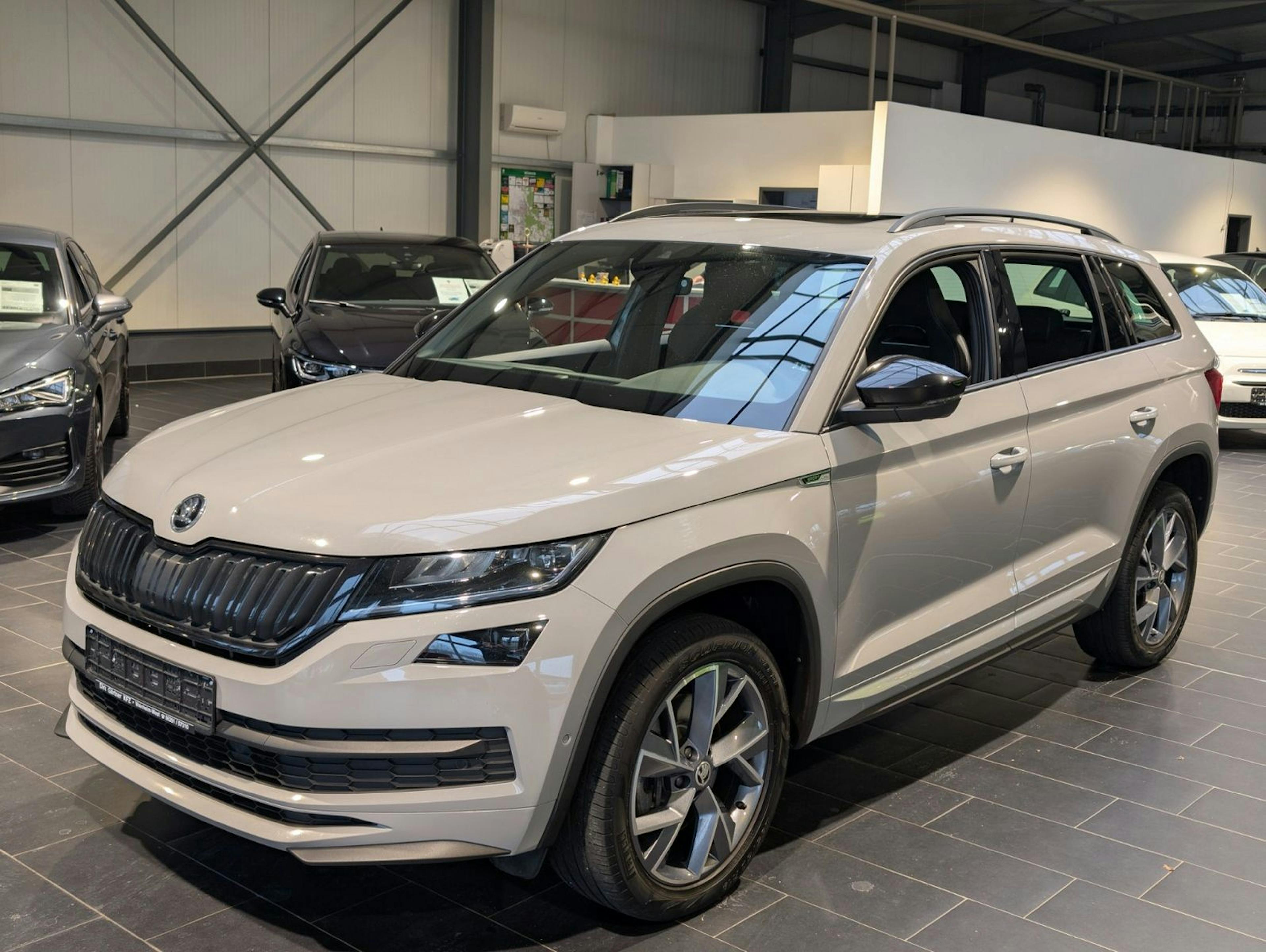 Ein weißer Škoda Kodiaq steht in einer Ausstellungshalle.