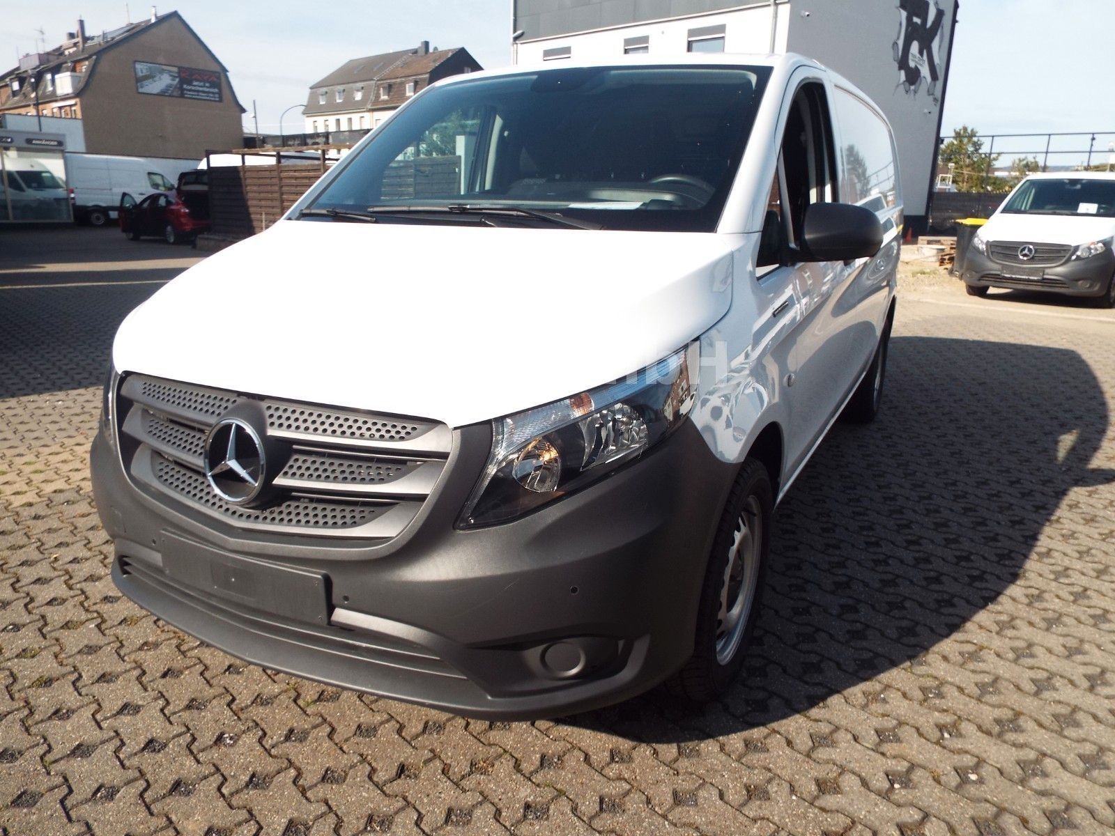 Ein weißer Mercedes Vito steht auf einer gepflasterten Fläche.