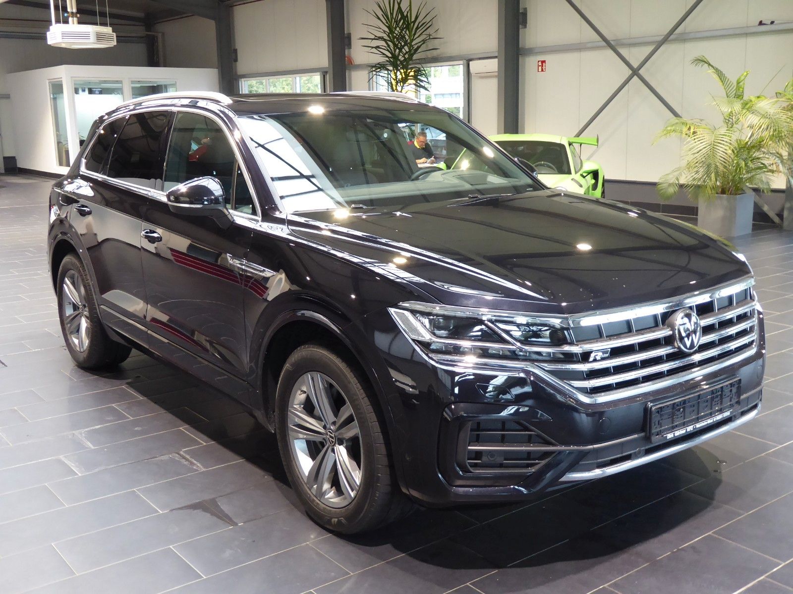 Ein schwarzer VW Touareg steht in einem Autohaus.