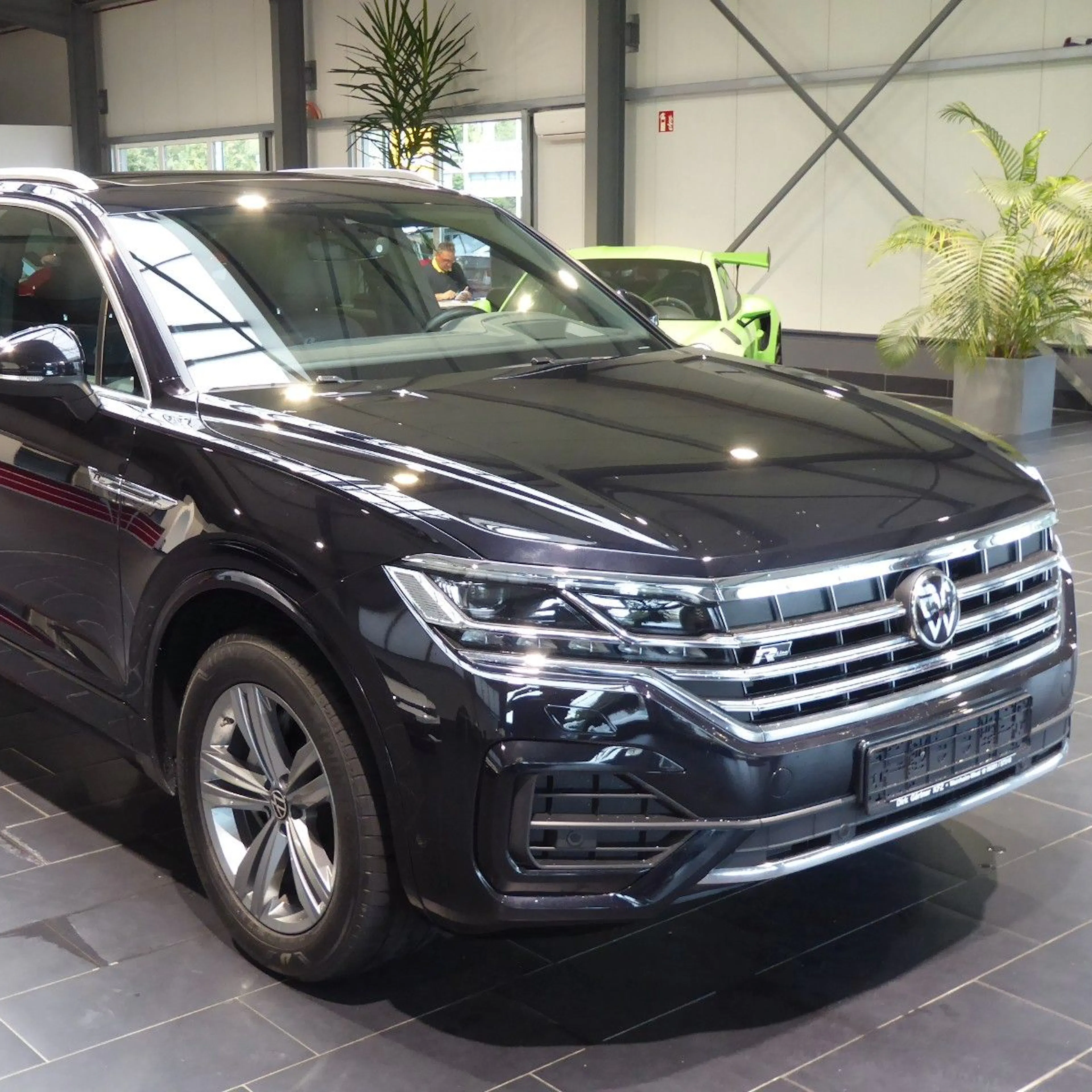 Ein schwarzer VW Touareg steht in einem Autohaus.