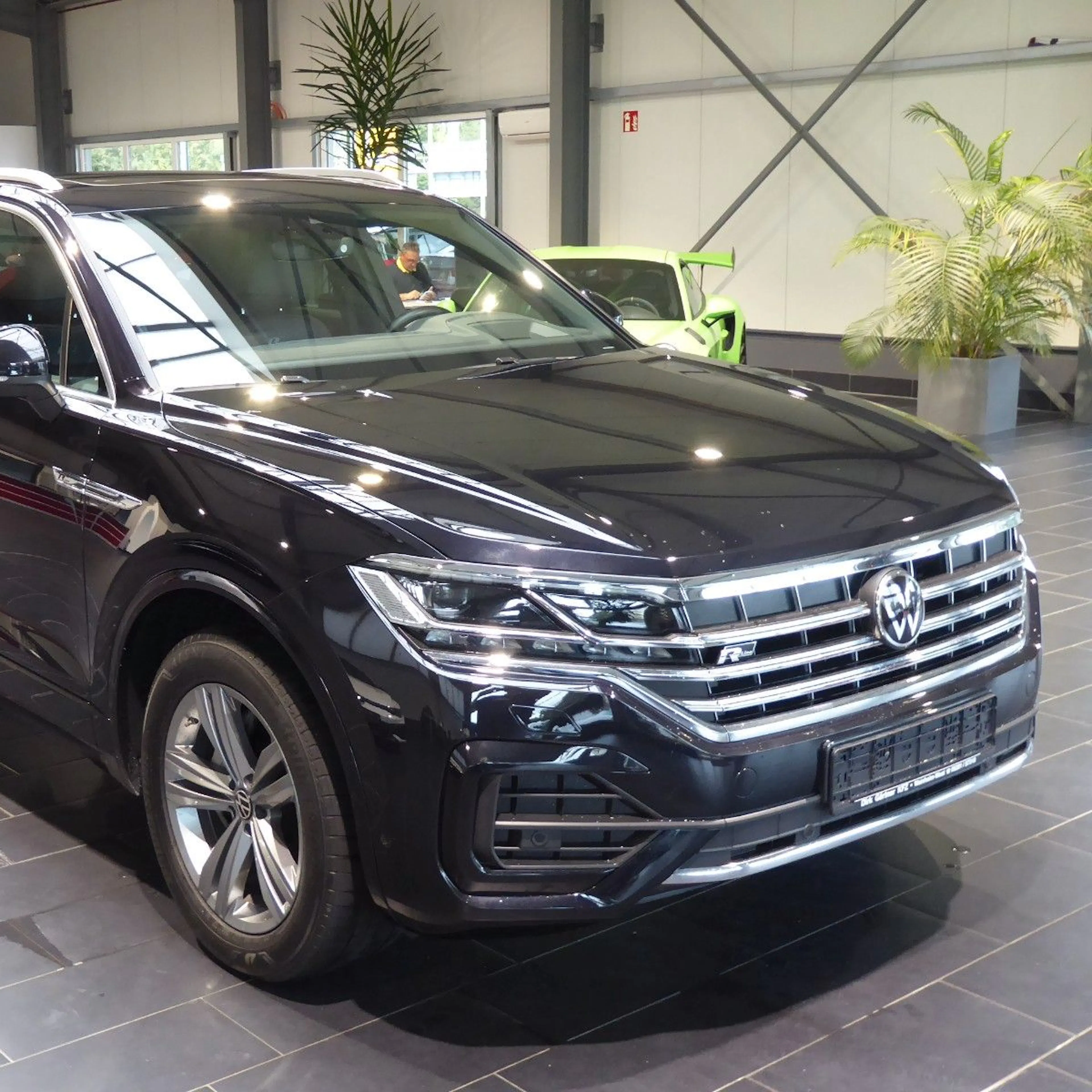Ein schwarzer VW Touareg steht in einem Autohaus.