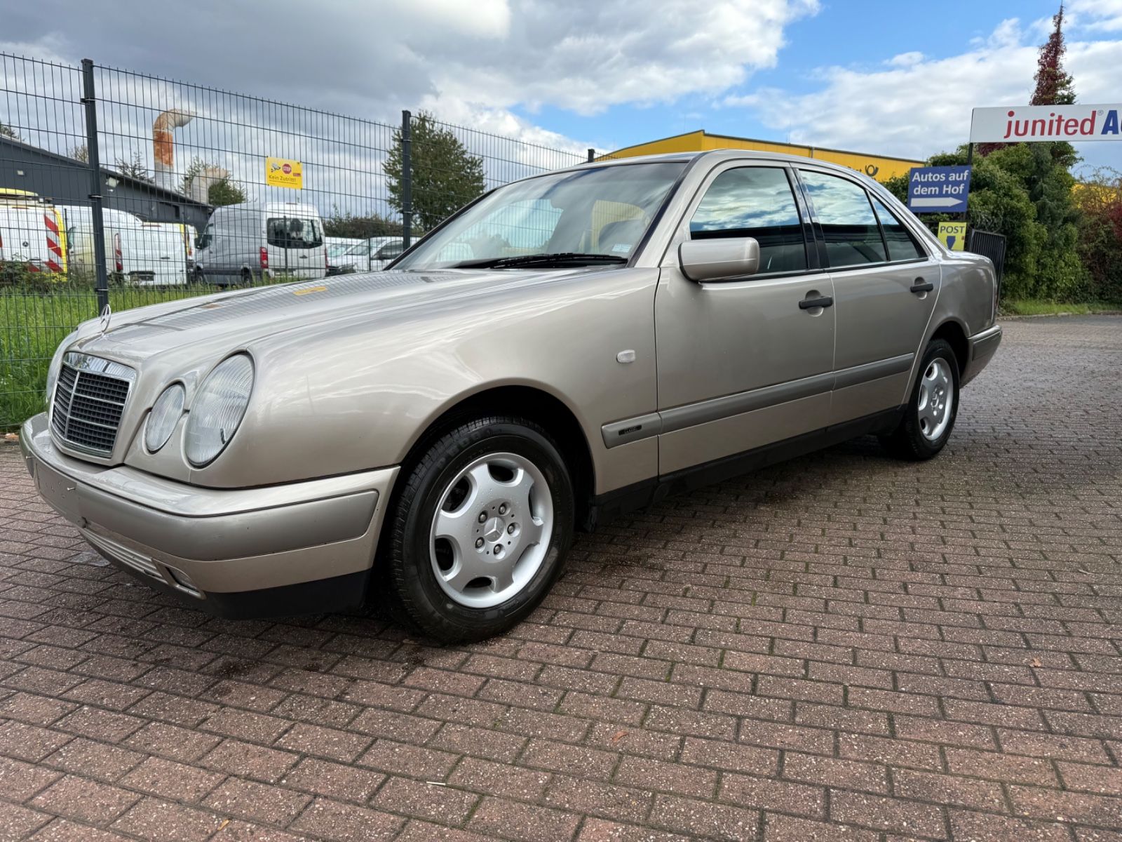 Eine silberne Mercedes E-Klasse steht auf einem Autohof.