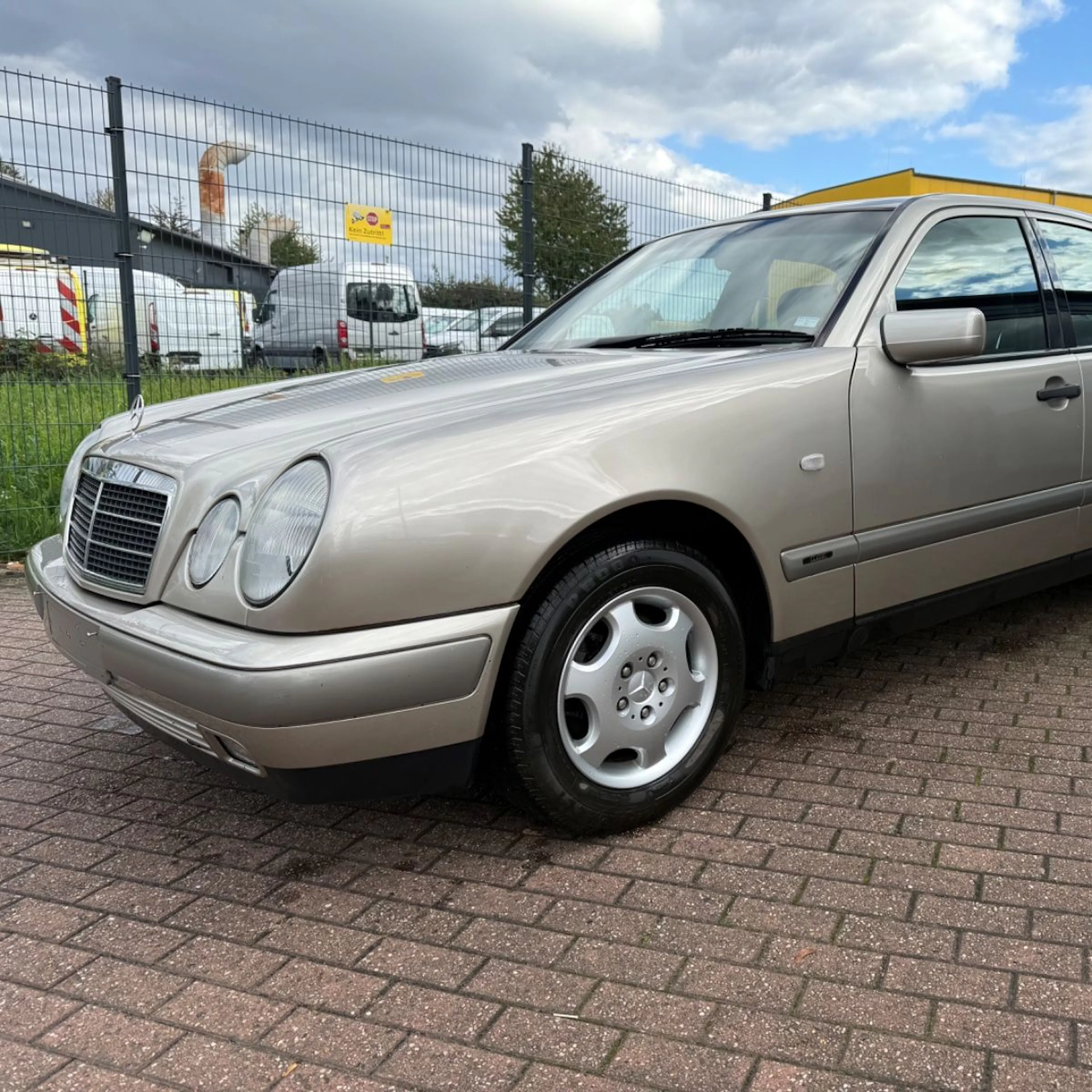Eine silberne Mercedes E-Klasse steht auf einem Autohof.