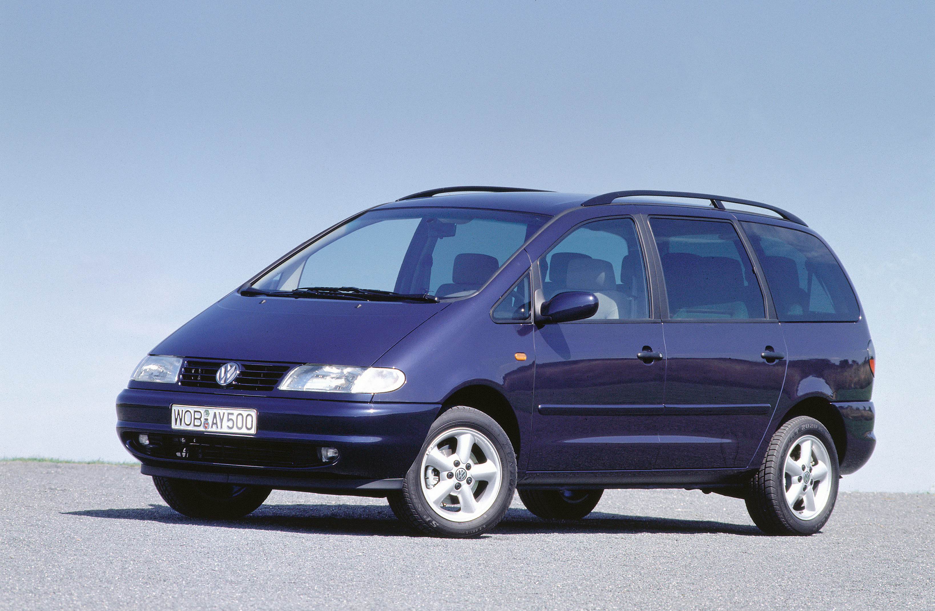 Ein blauer VW Sharan steht auf einer grauen Betonfläche.