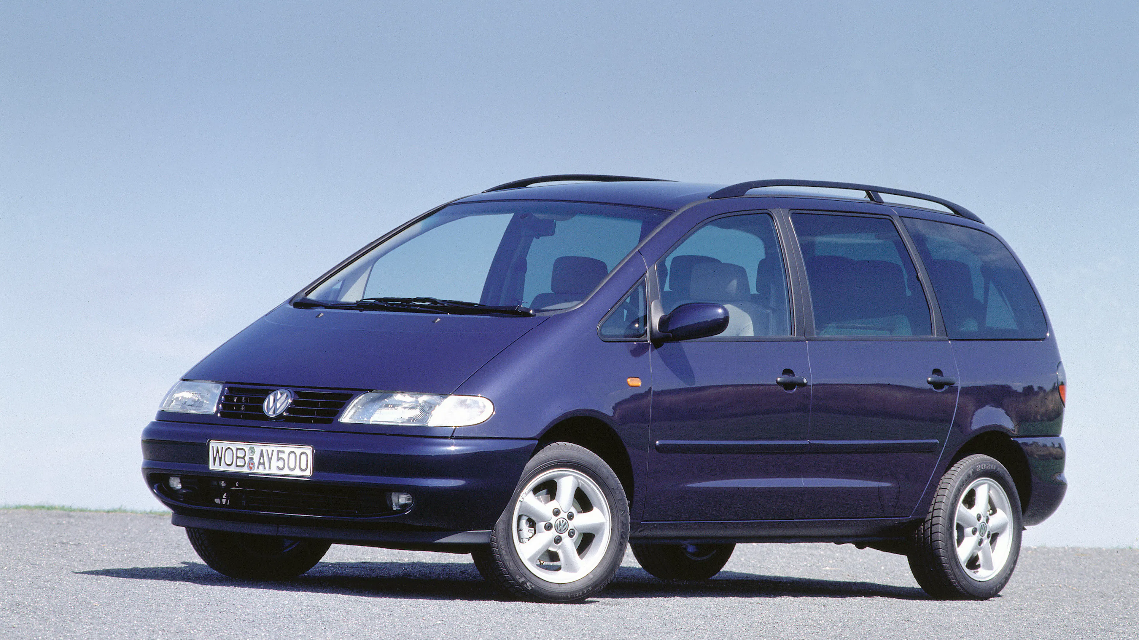 Ein blauer VW Sharan steht auf einer grauen Betonfläche.