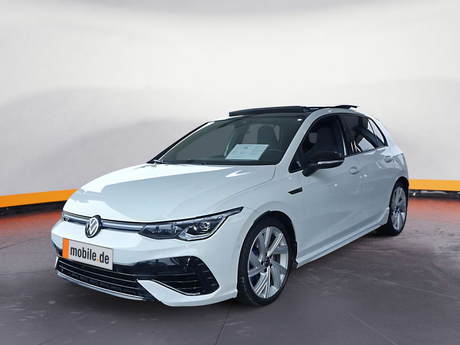 Ein weißer VW Golf steht in der Halle eines Händlers.
