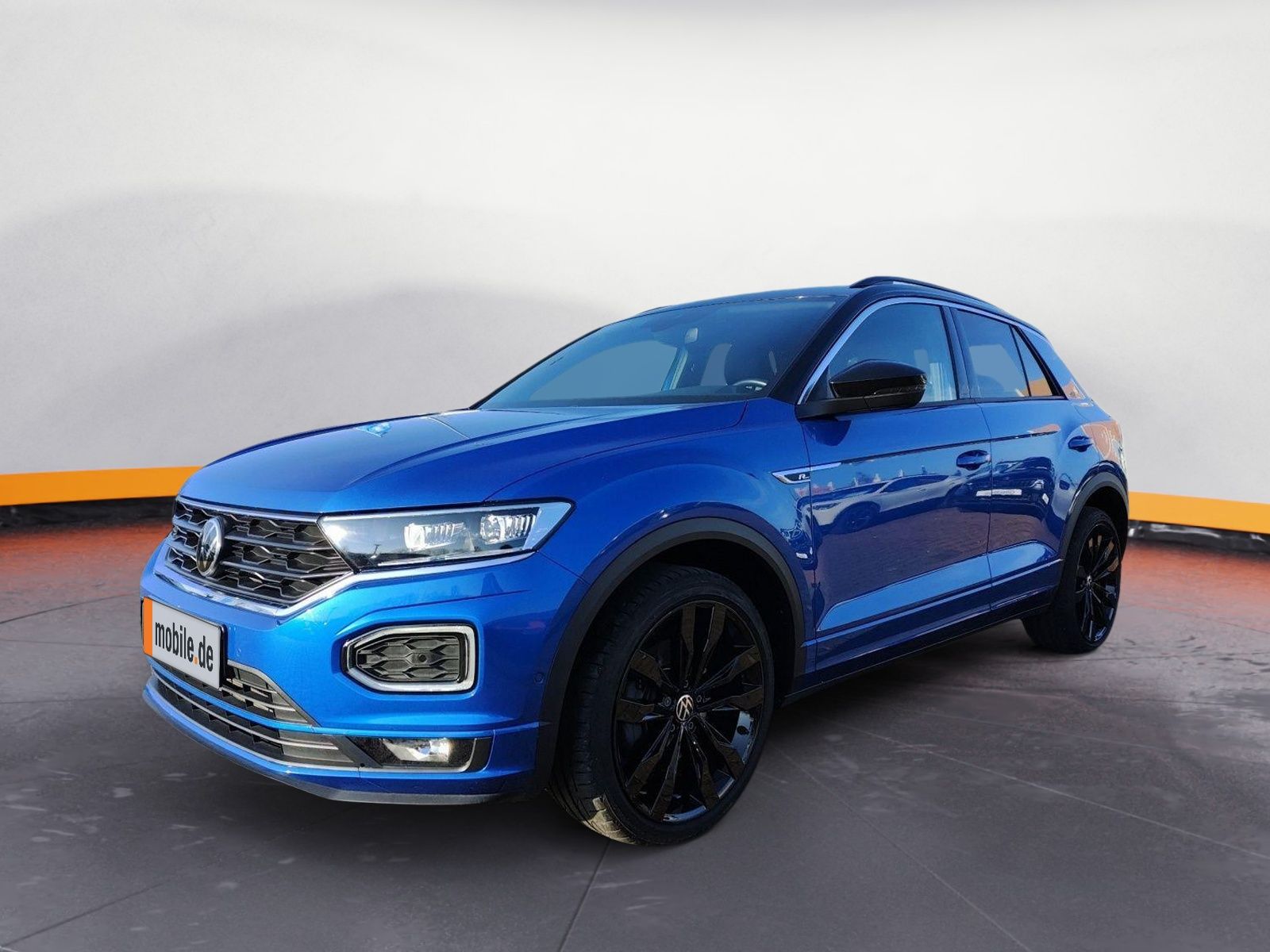 Ein blauer VW T-Roc steht in der Halle eines Händlers.