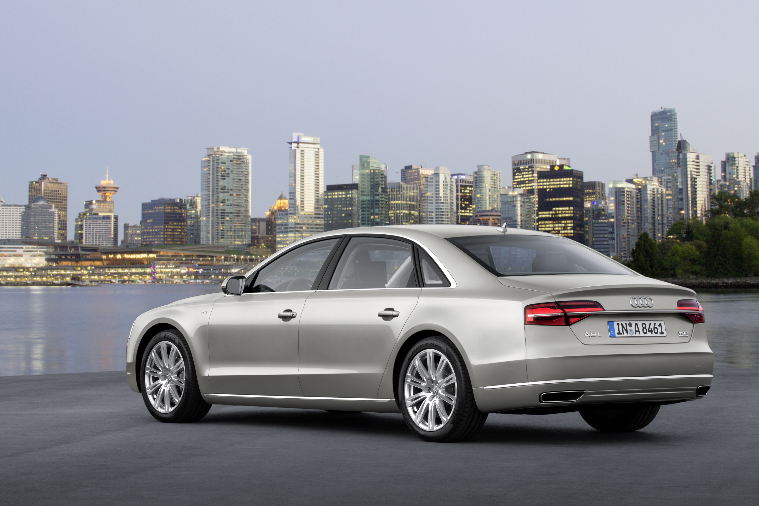 Ein silberner Audi A8 L steht vor der Skyline einer Großstadt.