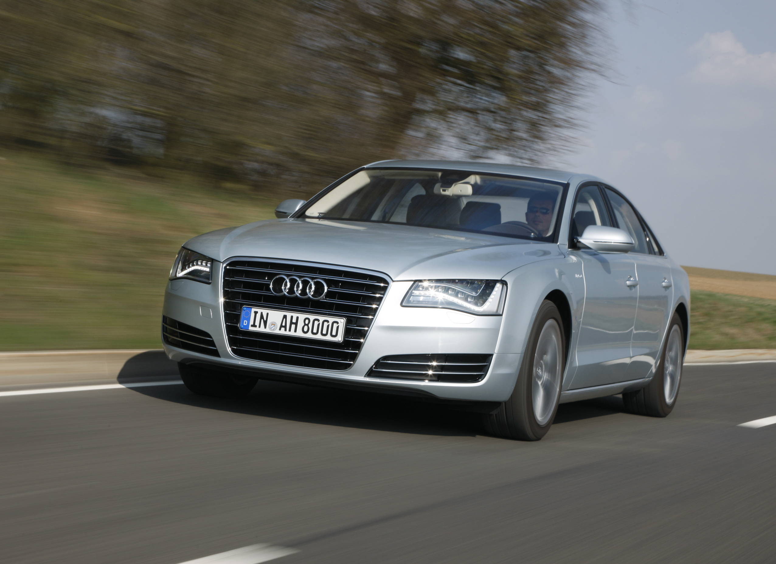 Ein silberner Audi A8 fährt auf einer Landstraße.