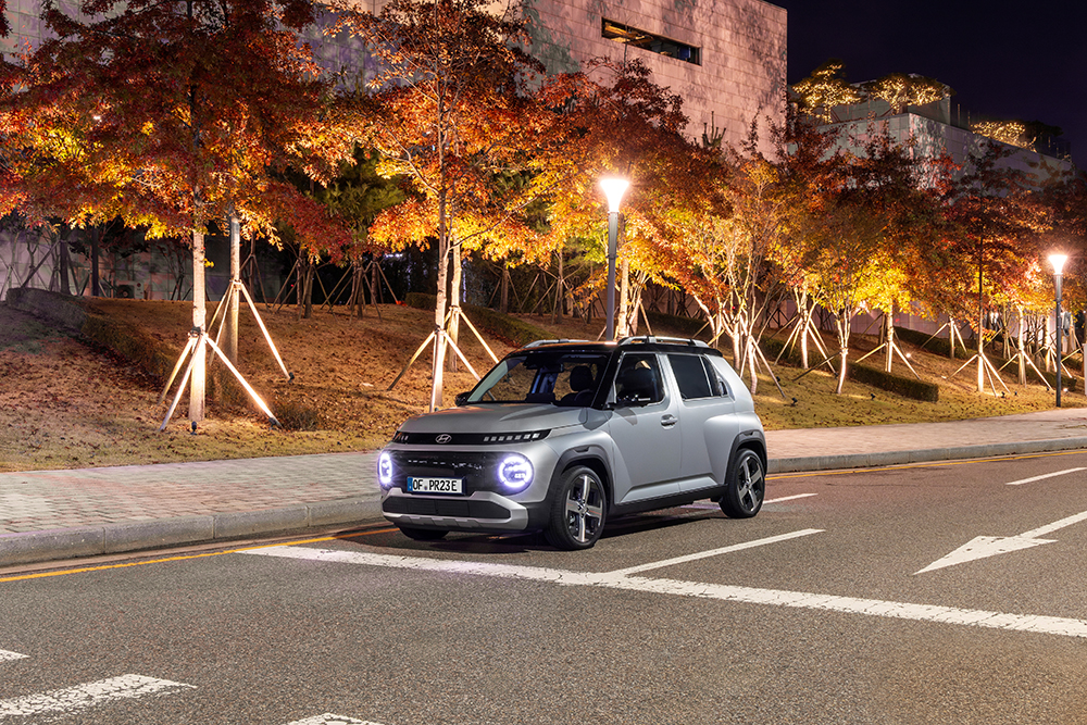 Hyundai INSTER auf einer Straße mit Abendbeleitung
