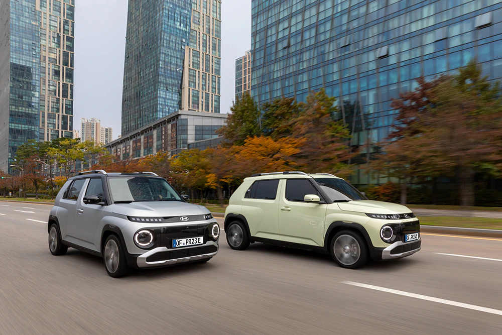 2 Hyundai INSTER fahren durch eine Großstadt