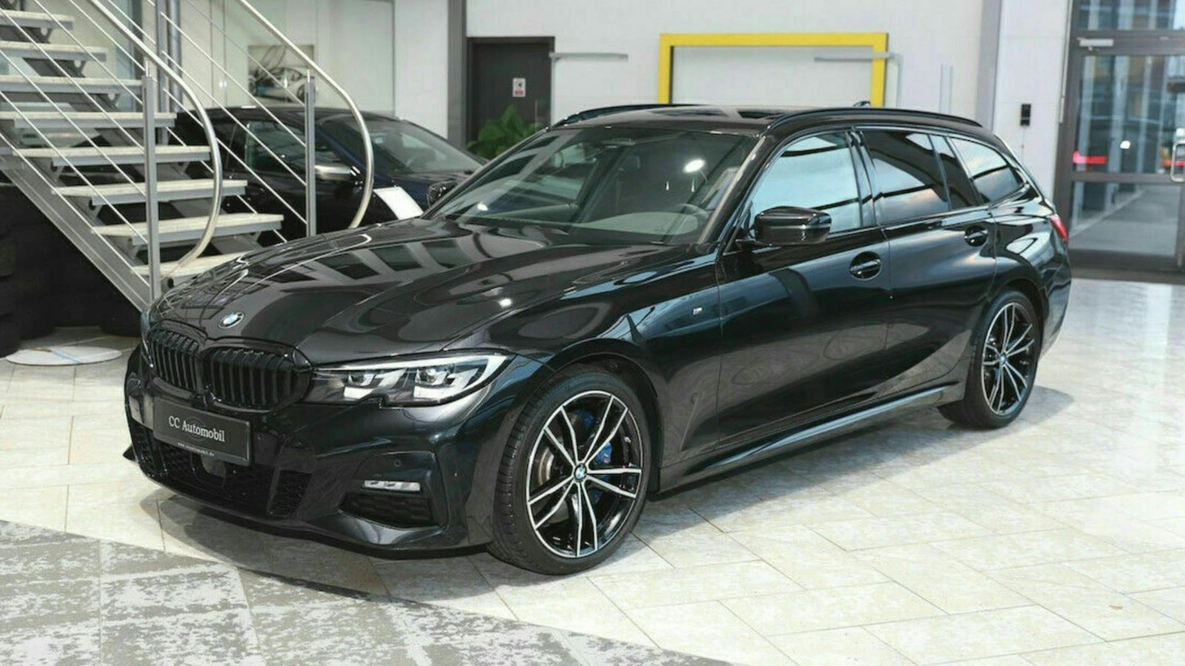 Ein schwarzer 3er BMW steht im Showroom eines Autohauses
