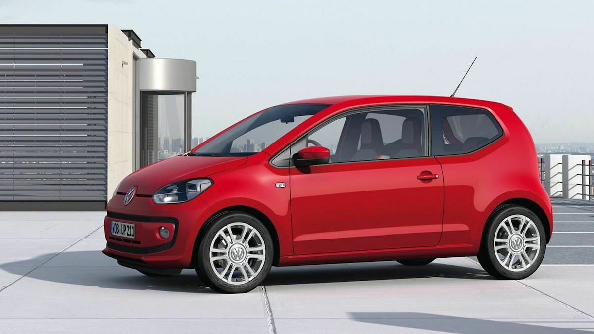 Roter VW Up in der Seitenansicht auf einem Häuserdach