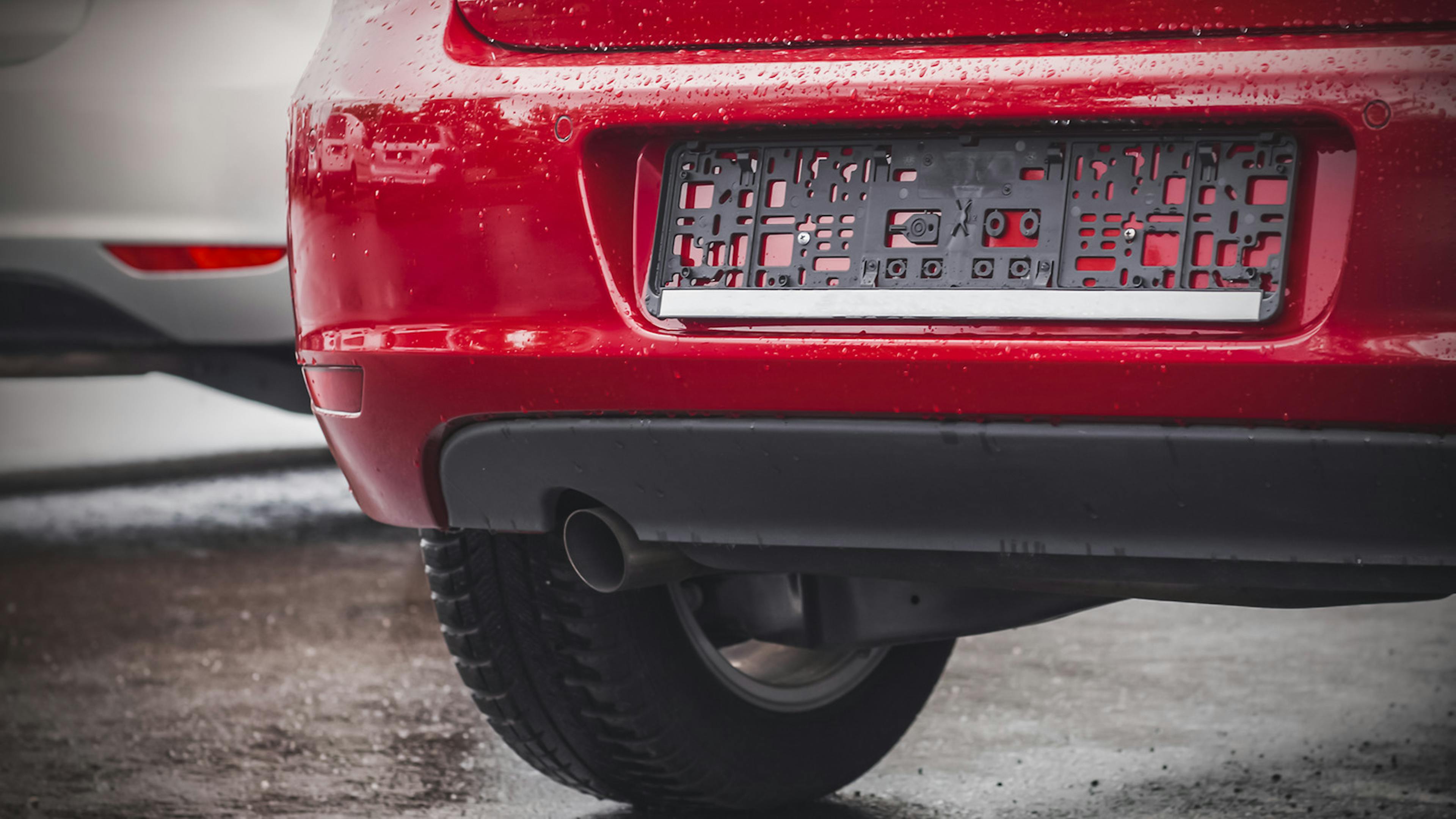 Einem roten Auto fehlt das Kennzeichen an der Heckstoßstange