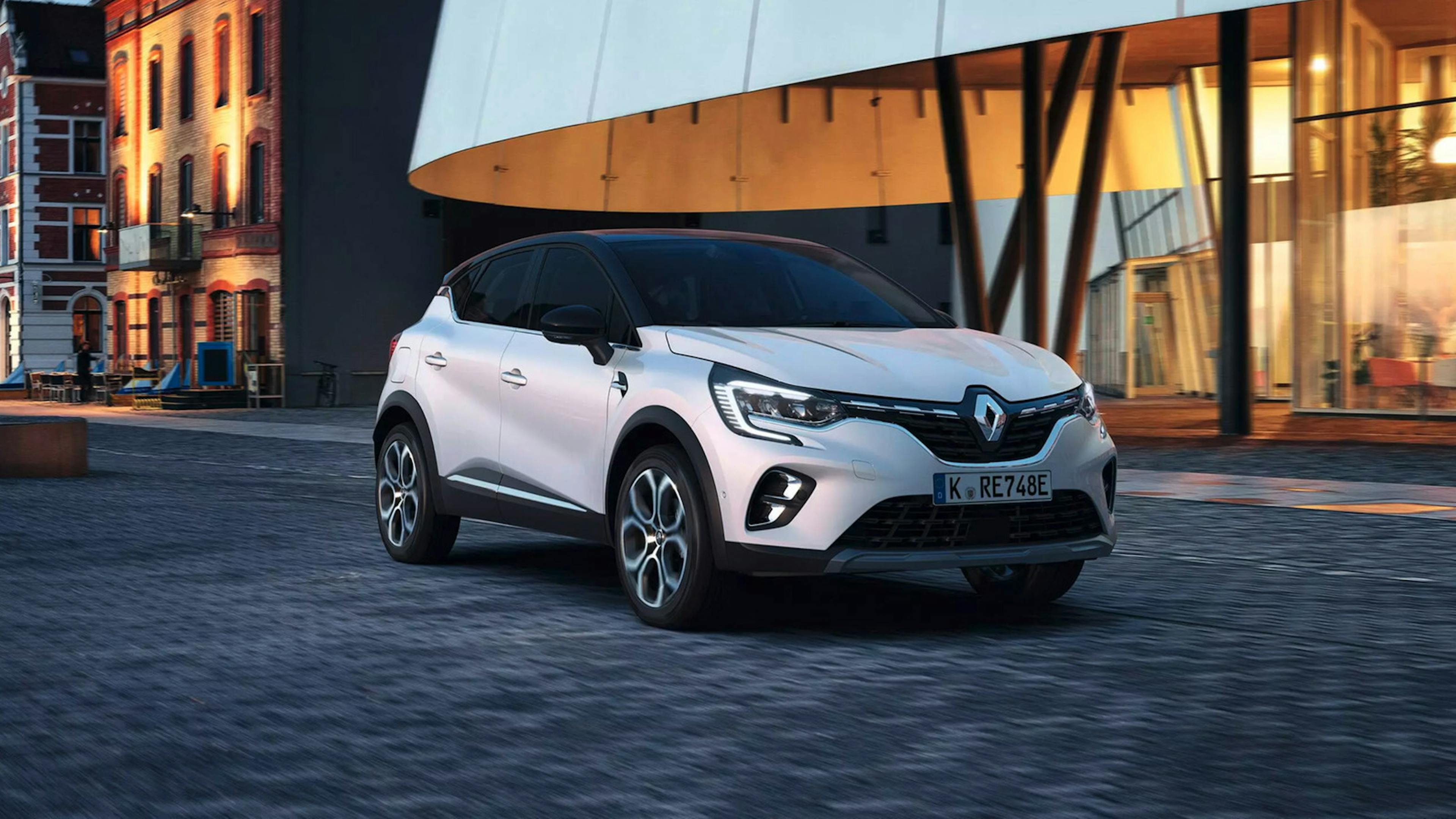 Ein weißer Renault Captur steht vor einer urbanen Kulisse