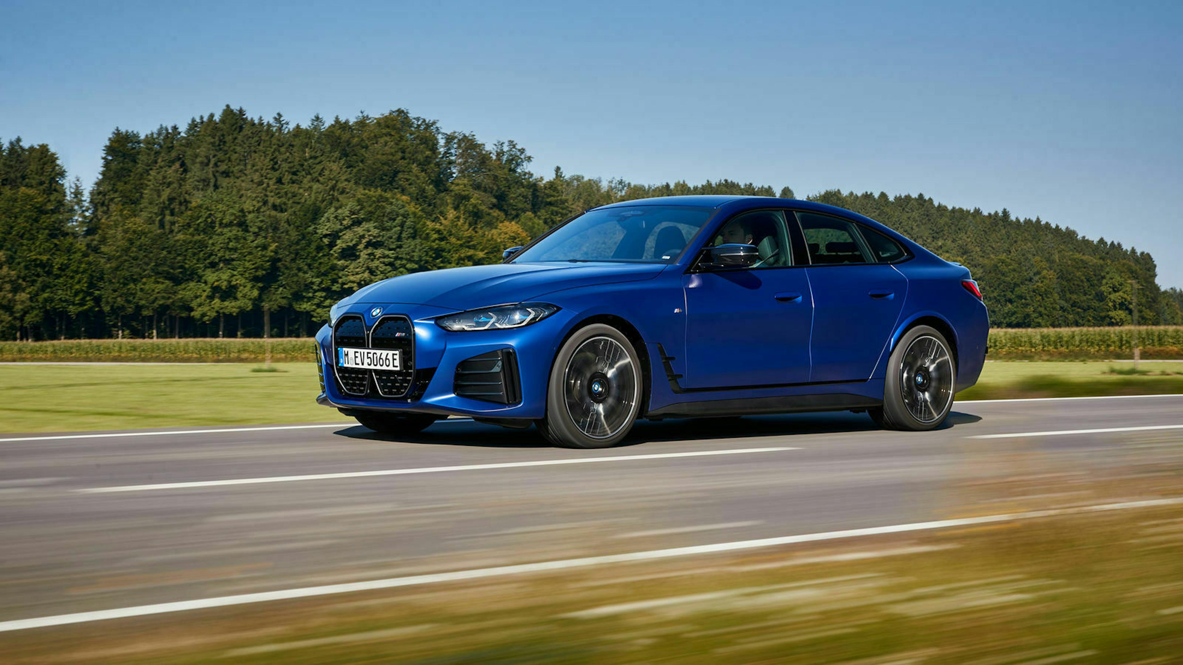 Ein blauer BMW i4 M50 fährt über eine Landstraße