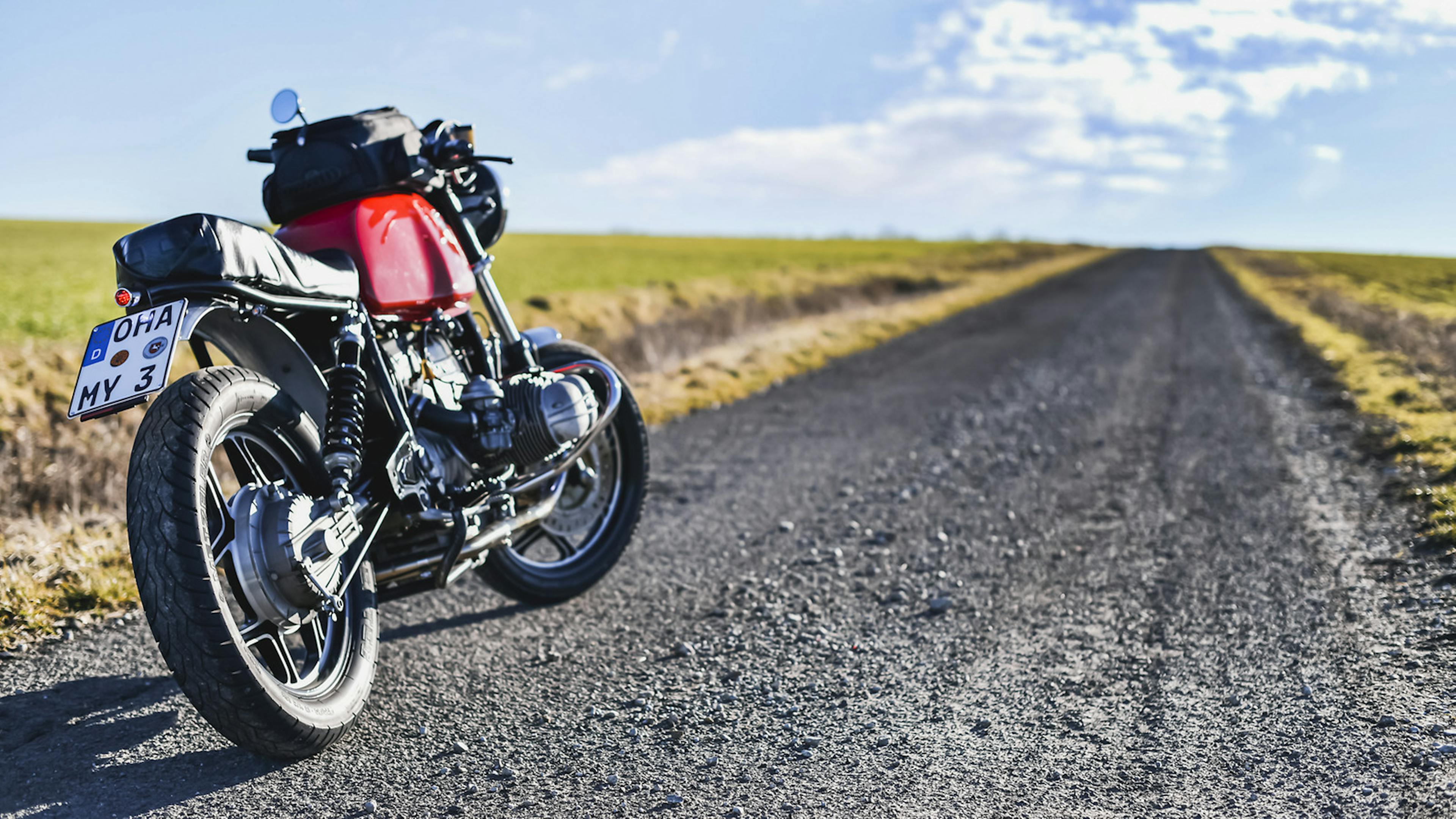 Motorrad steht auf einem Schotterweg
