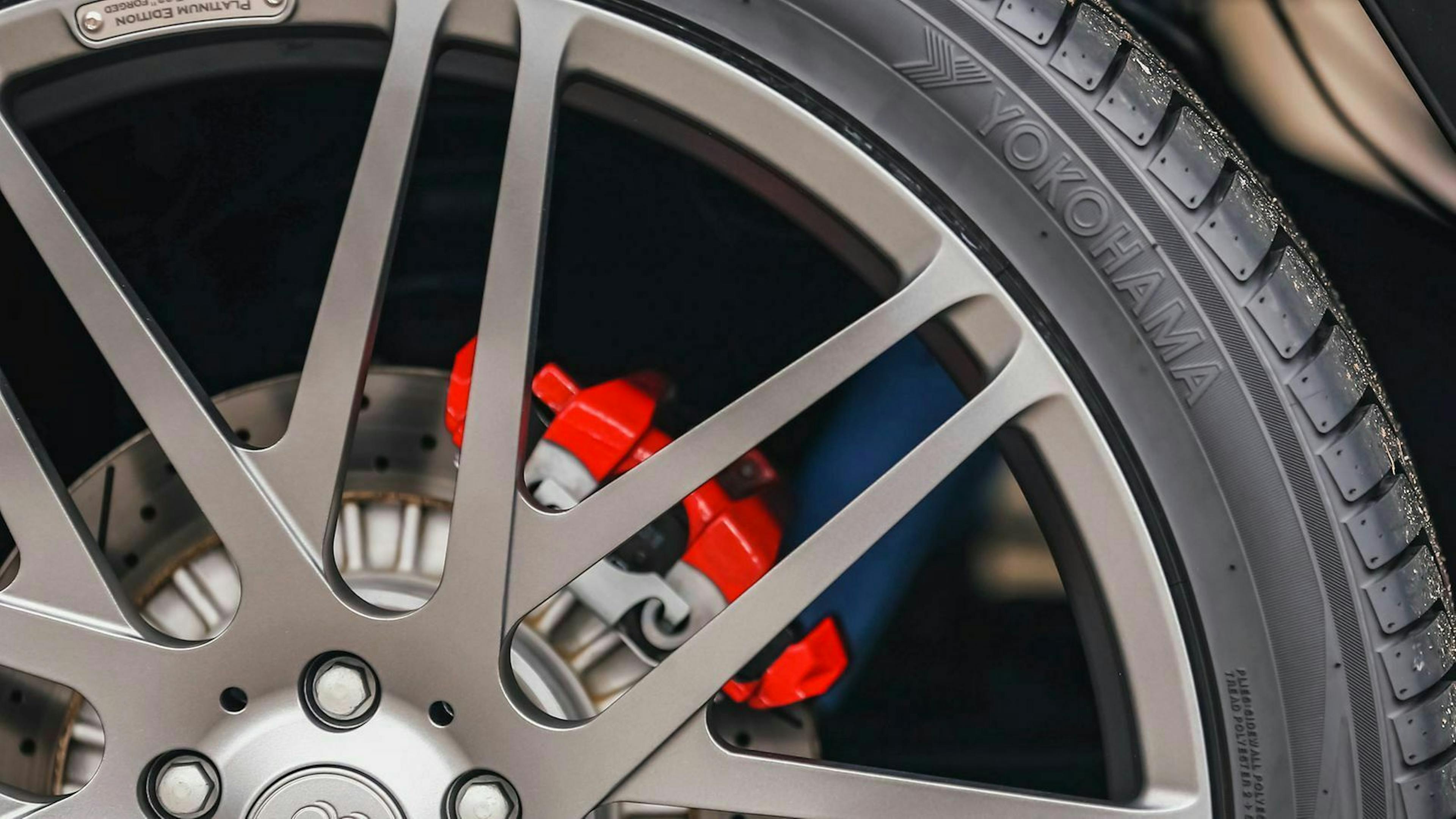 Ein rot lackierter Bremssattel in einer großen Leichtmetallfelge.