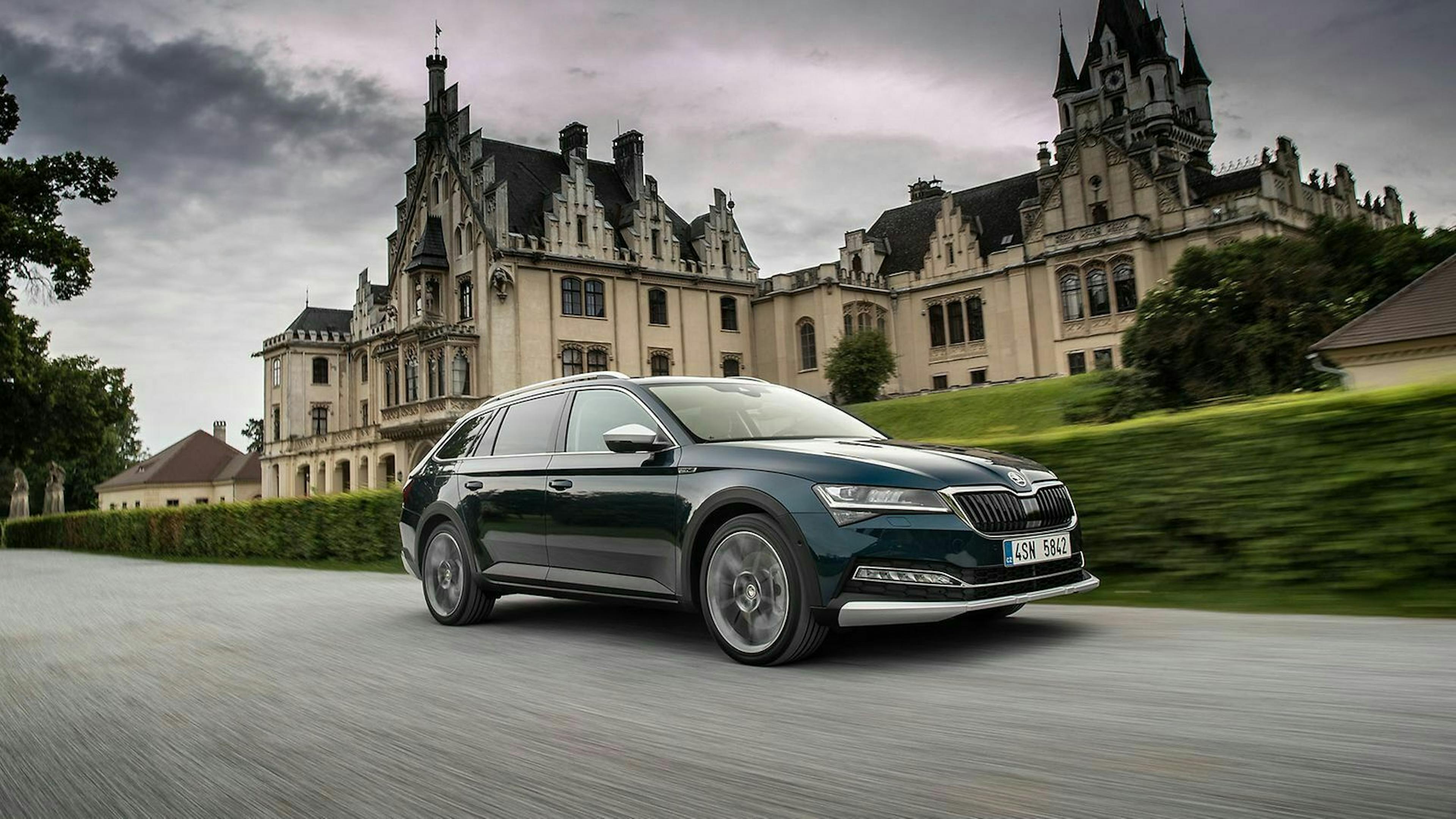 Škoda Superb Scout in Fahrt: Aufnahme von vorn rechts, im Hintergrund ein Schloss