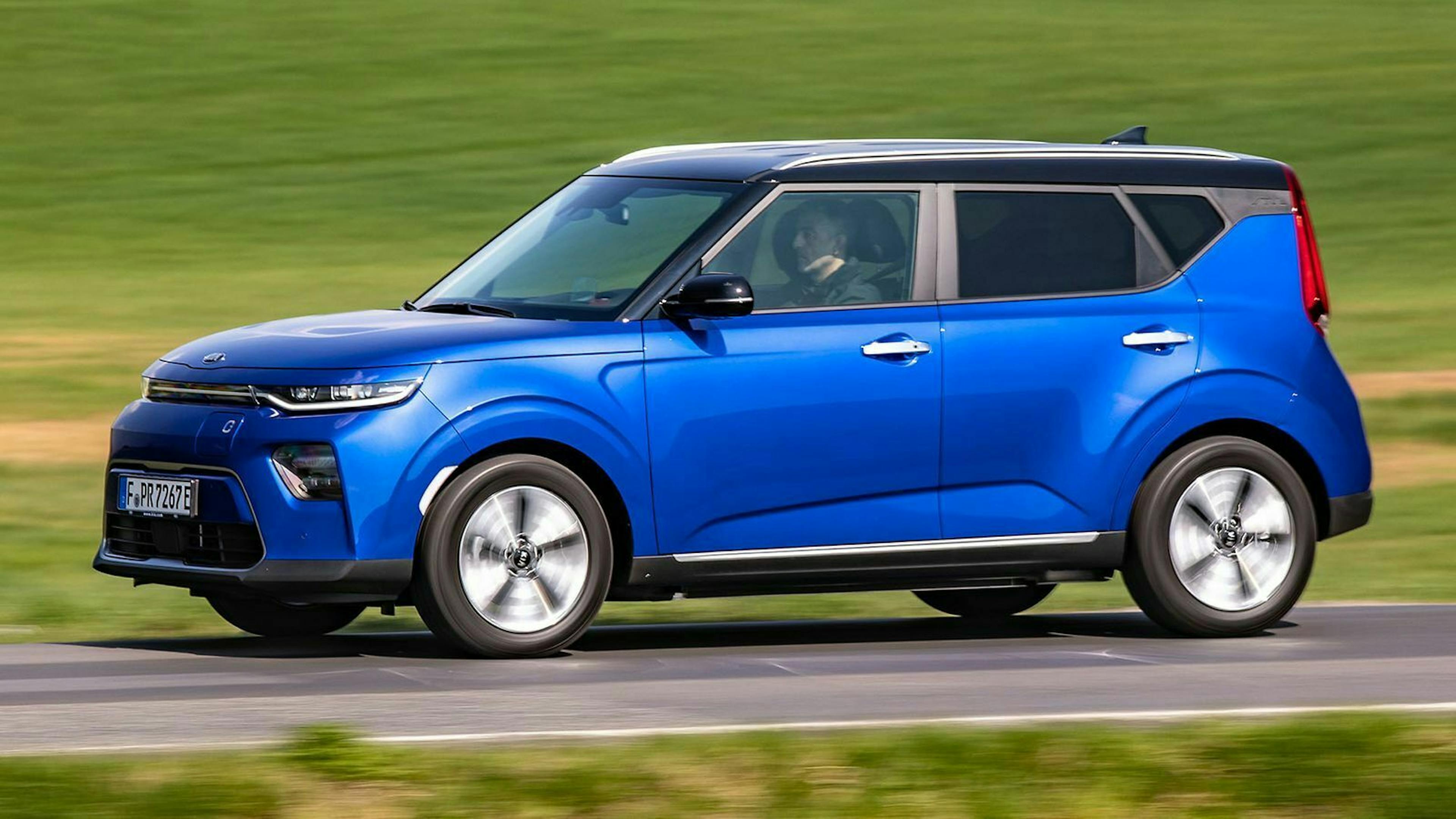 Ein blauer Kia e-Soul auf der Landstraße - Seitenansicht