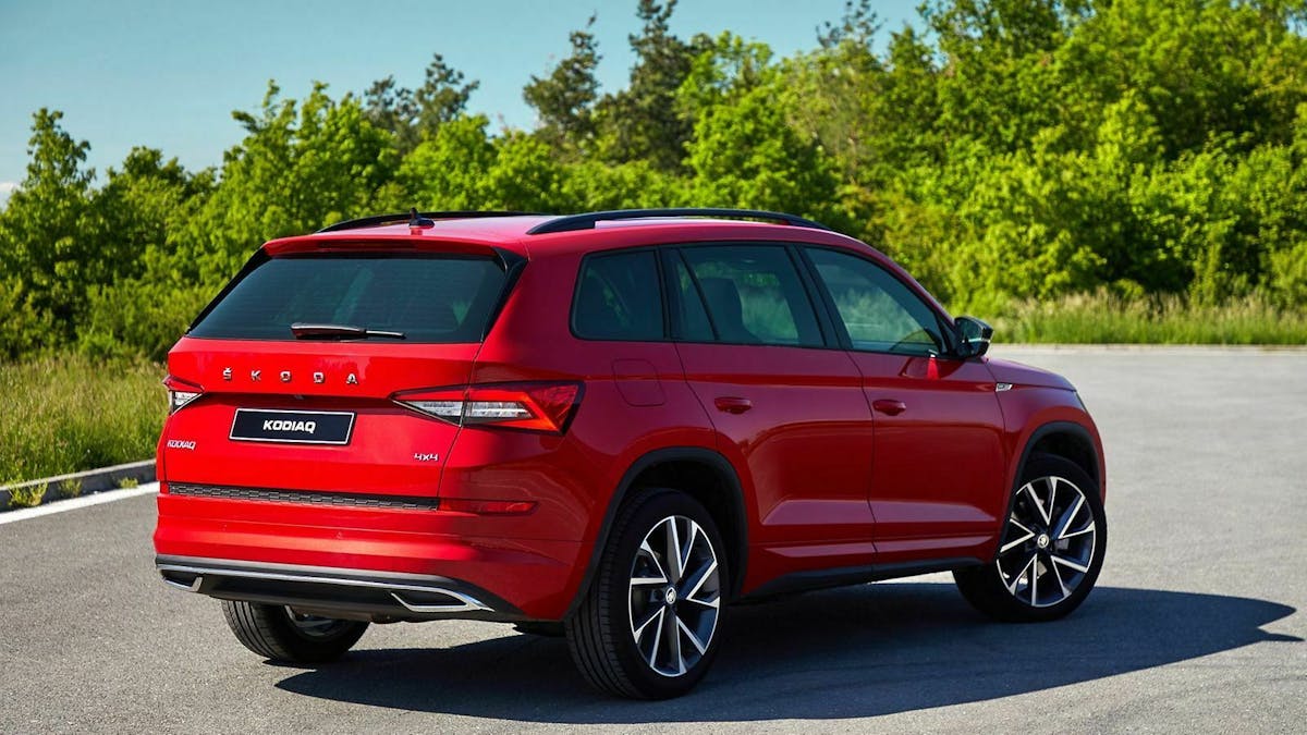Ein roter Skoda Kodiaq steht auf einem Parkplatz - hintere Seitenansicht