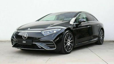 Ein schwarzer Mercedes-Benz EQS steht vor einer weißen Wand