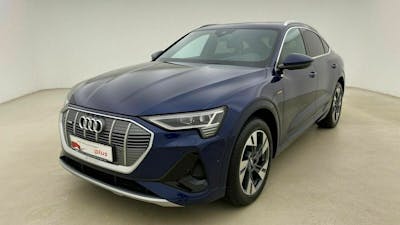 Ein blauer Audi e-tron GT steht in einem beigefarbenen Raum