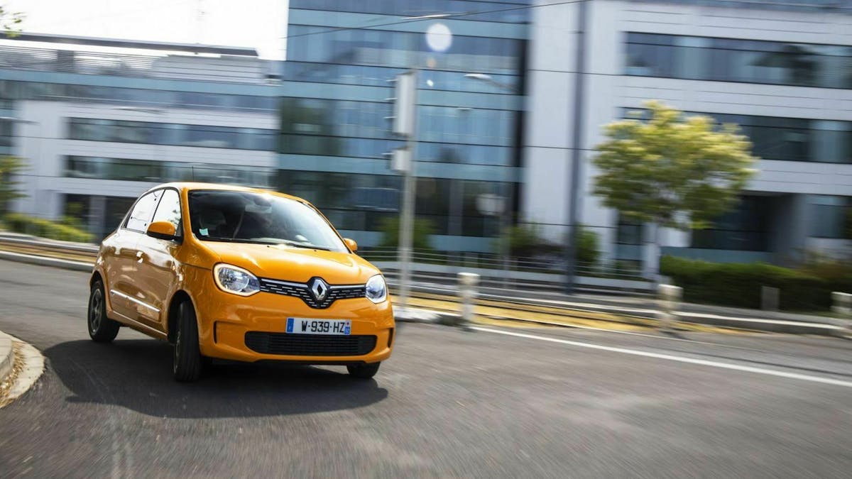 Ein gelber Renault Twingo fährt durch eine Stadt