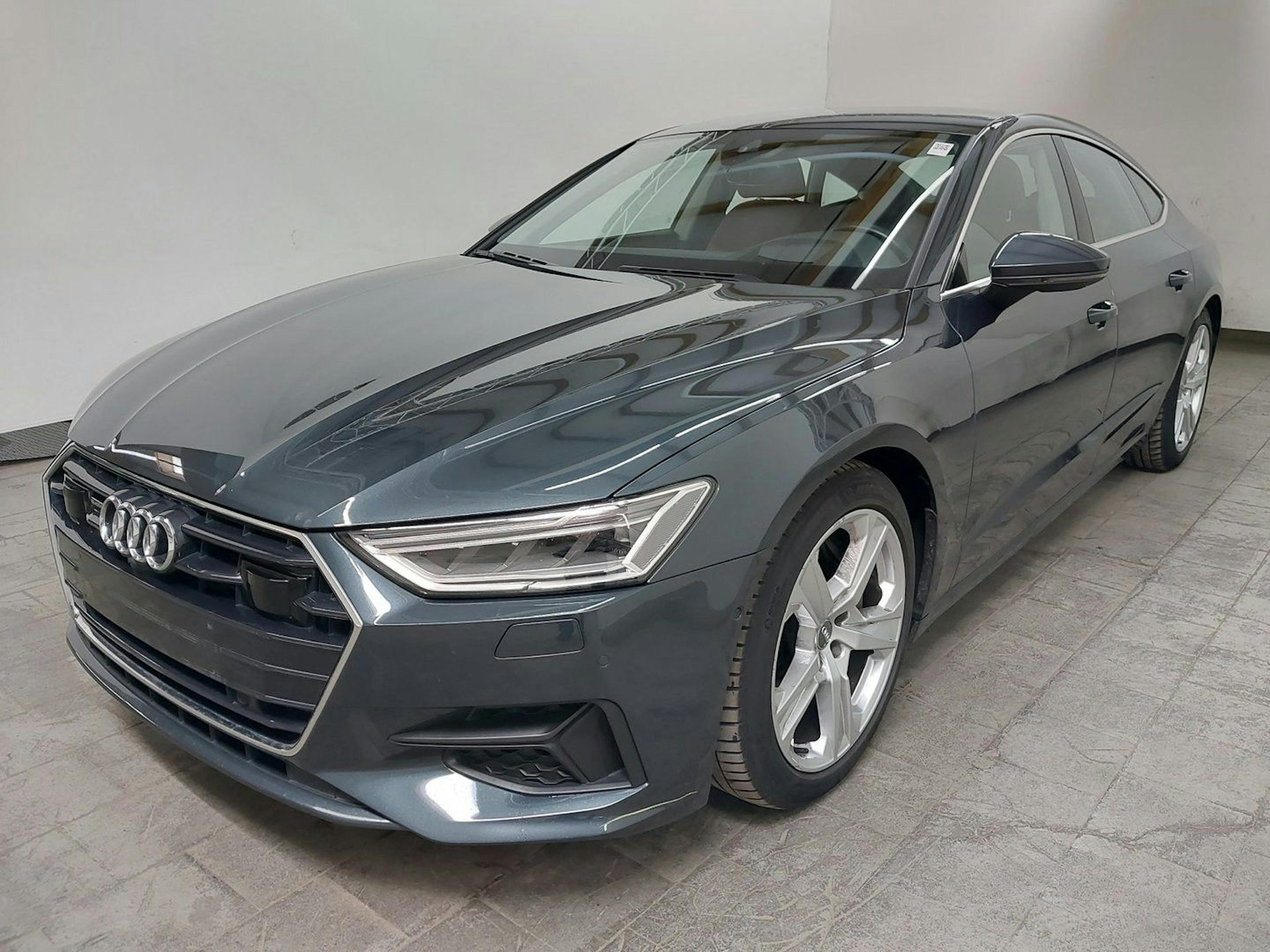 Ein grauer Audi A7 parkt in einem Autohaus.
