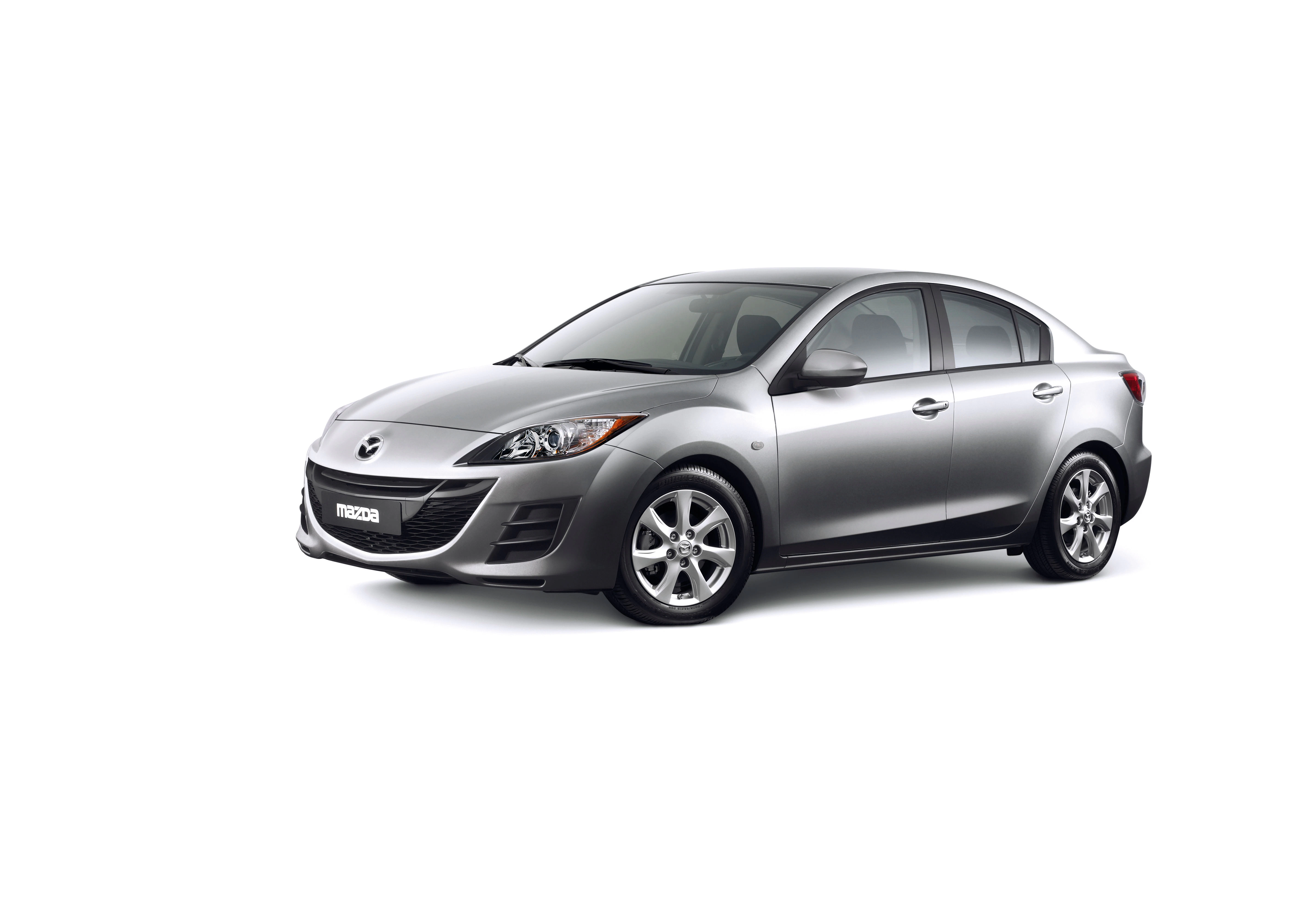 Silberner Mazda 3 Limousine, seitliche Frontansicht, auf weißem Hintergrund. Fahrzeug mit sportlichem Design und fünf Speichenfelgen.