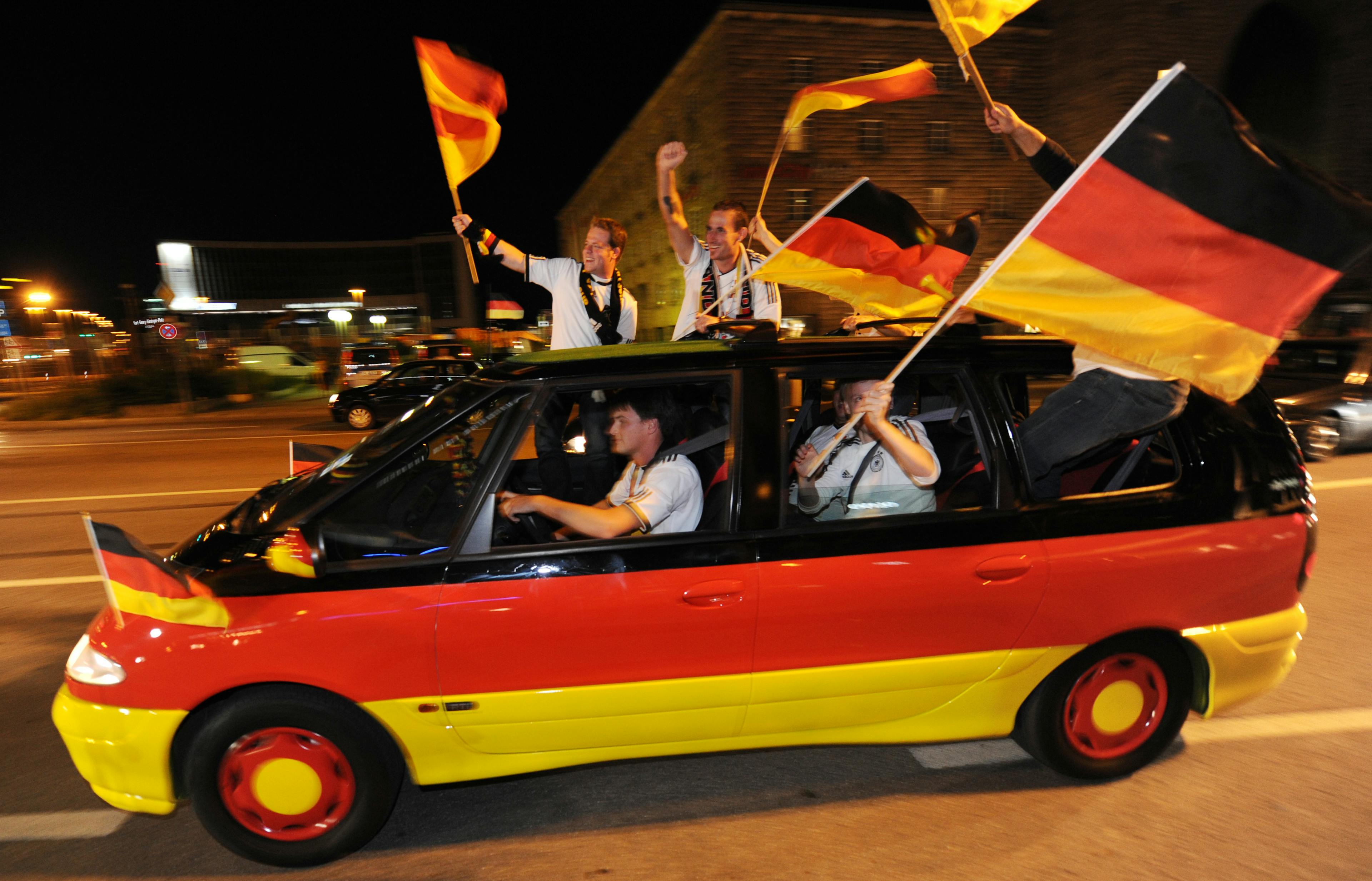 Ein Minivan in Deutschland-Farben mit Fussball-Fans.