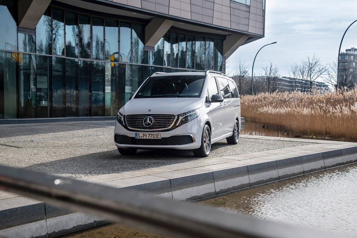 Ein weißer Mercedes Benz EQV parkt vor einem Gebäude