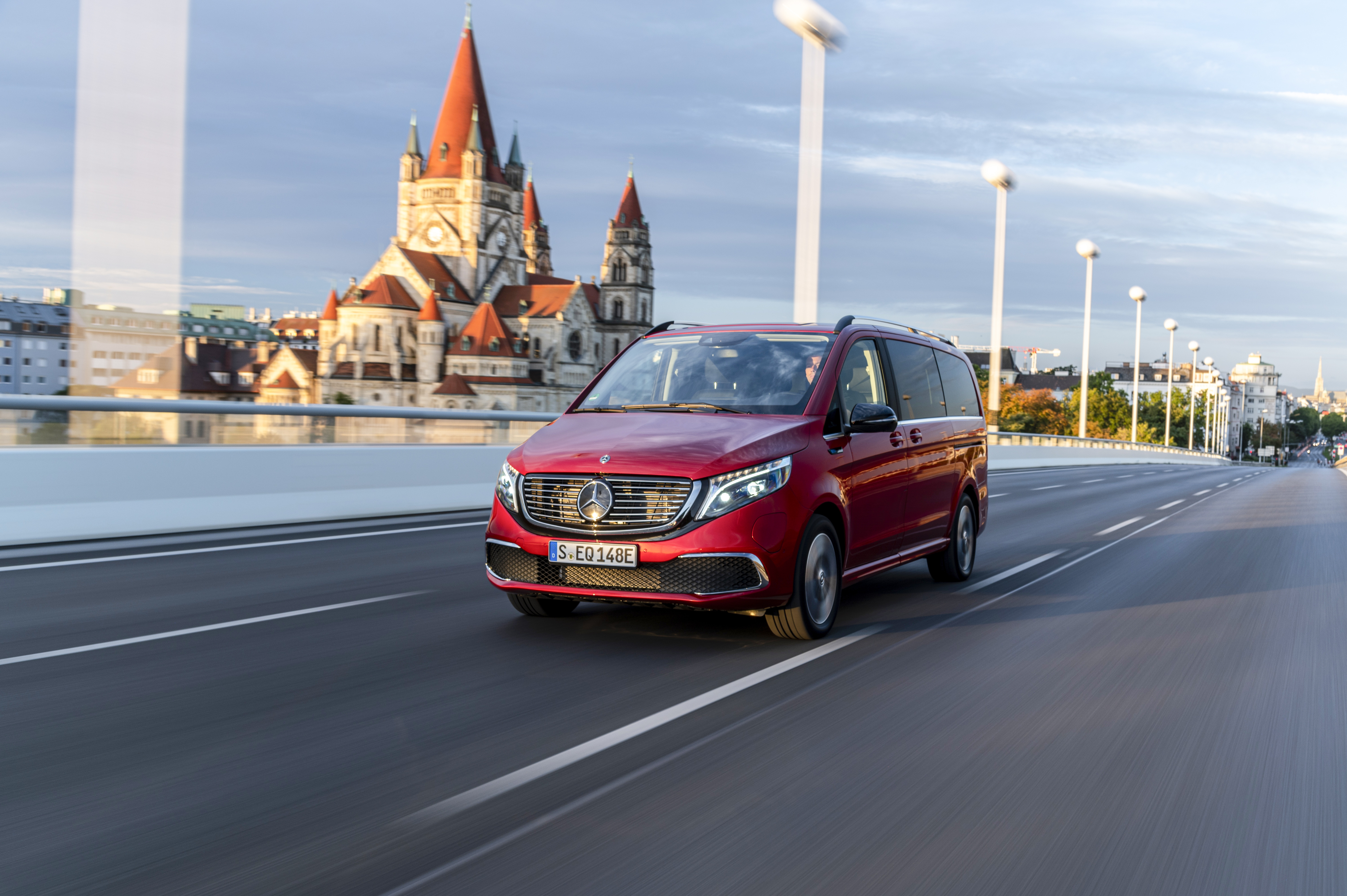 Ein roter Mercedes Benz EQV fährt in urbaner Umgebung