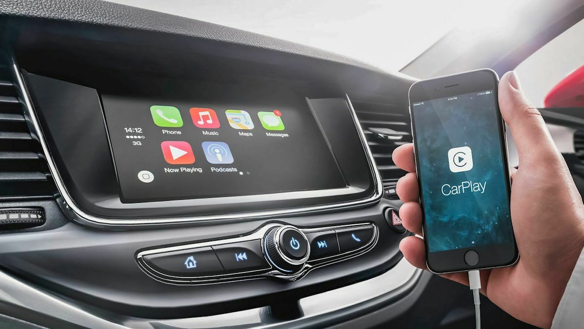 Jemand hält sein iPhone vor den Infotainment-Bildschirm seines Opels.