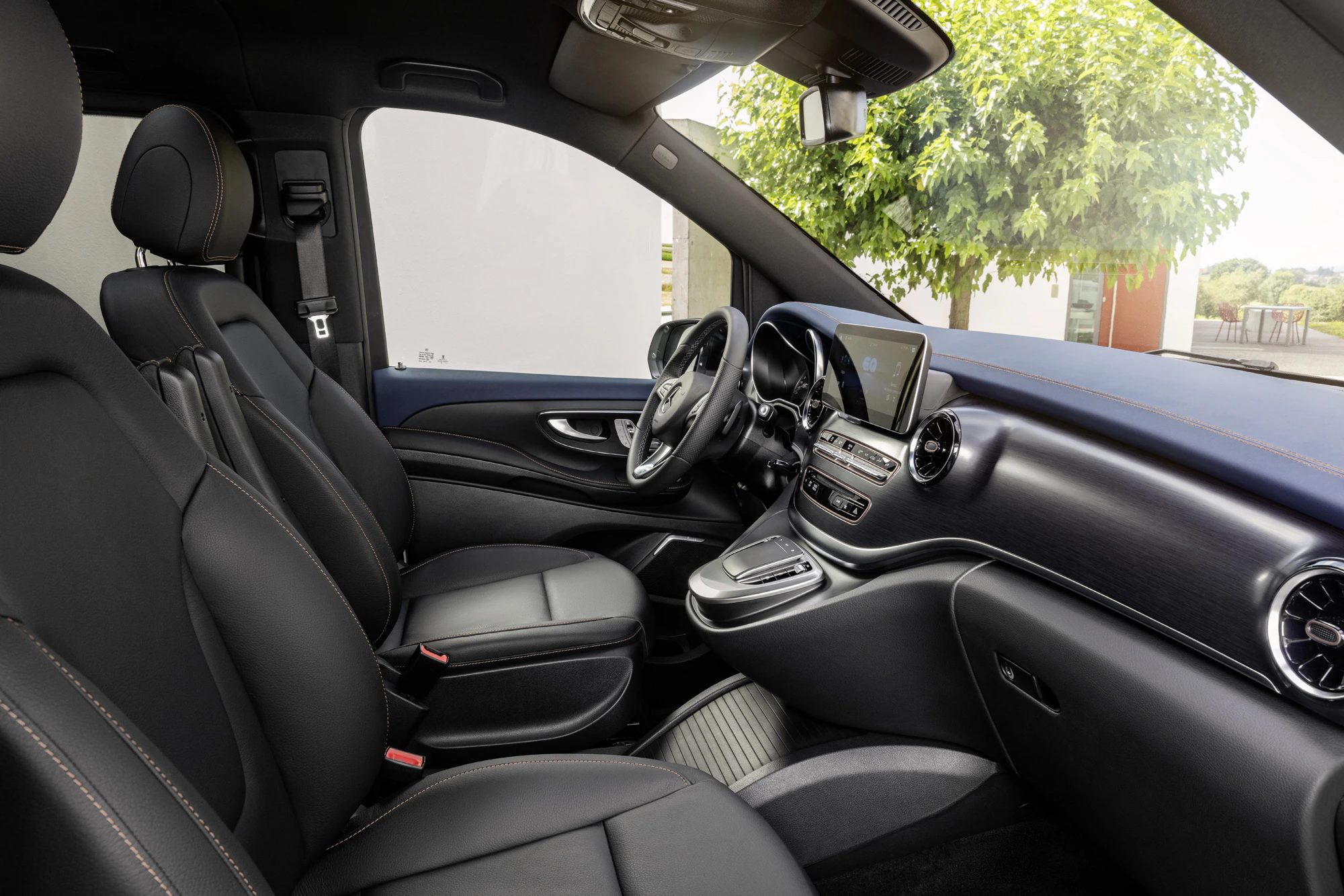Luxuriöser Fahrzeuginnenraum mit schwarzen Ledersitzen, modernem Armaturenbrett und Touchscreen-Display, aufgenommen bei Tageslicht.