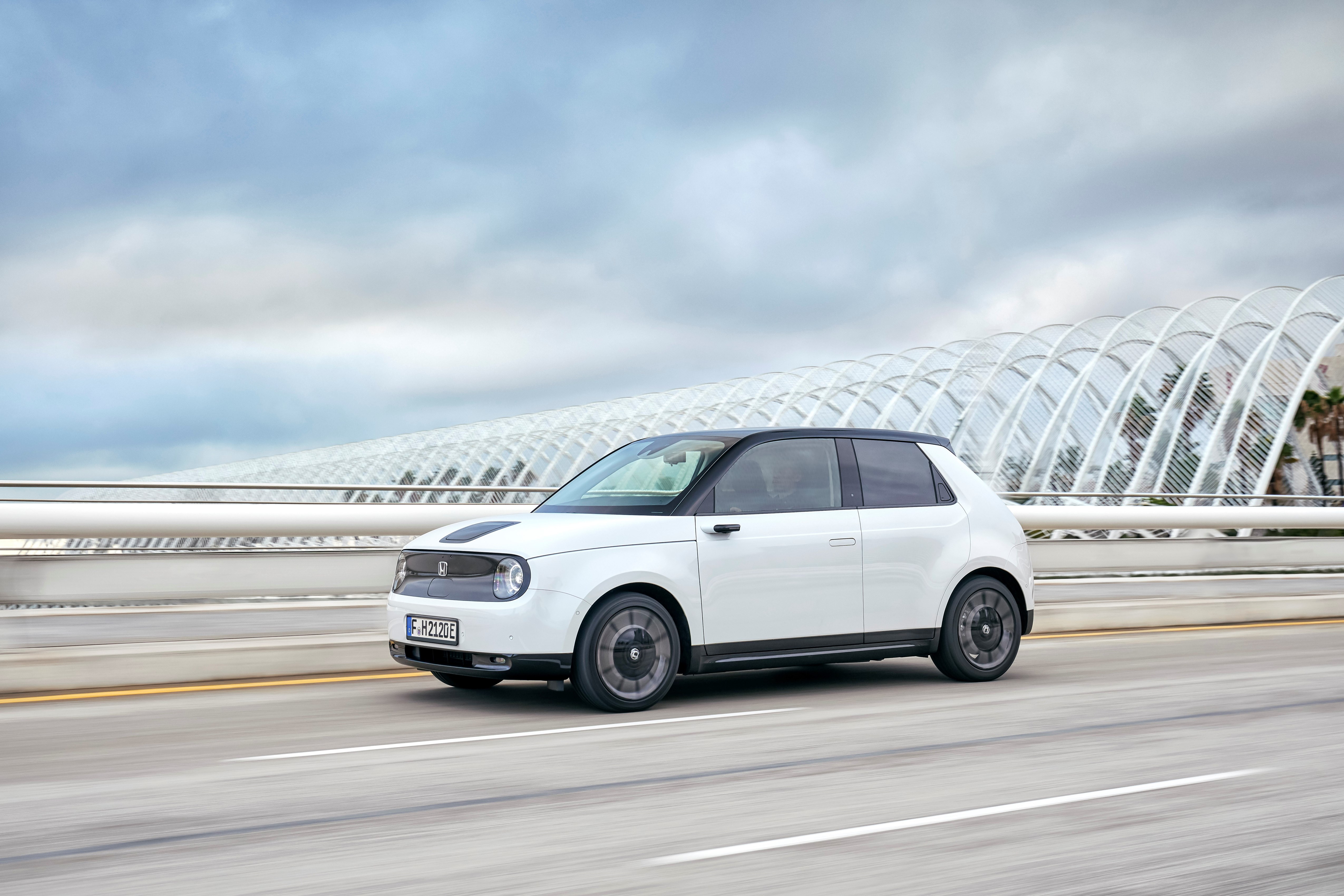 A white Honda e driving on a road