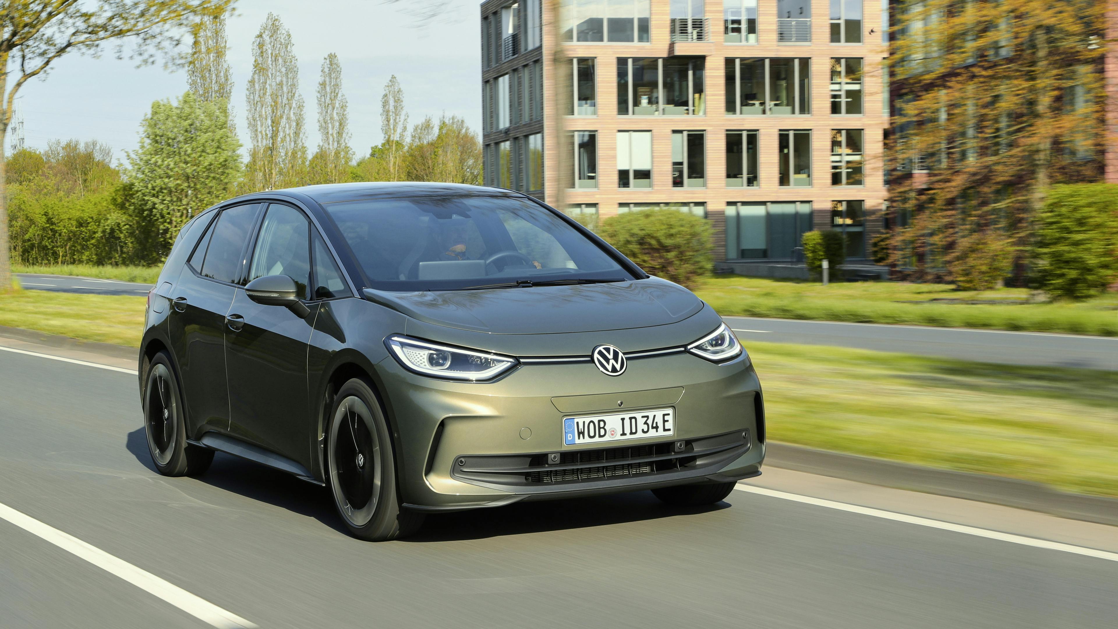 Ein grüner VW ID.3 fährt auf einer Hauptstrasse mit einem Bürogebäude im Hintergrund.