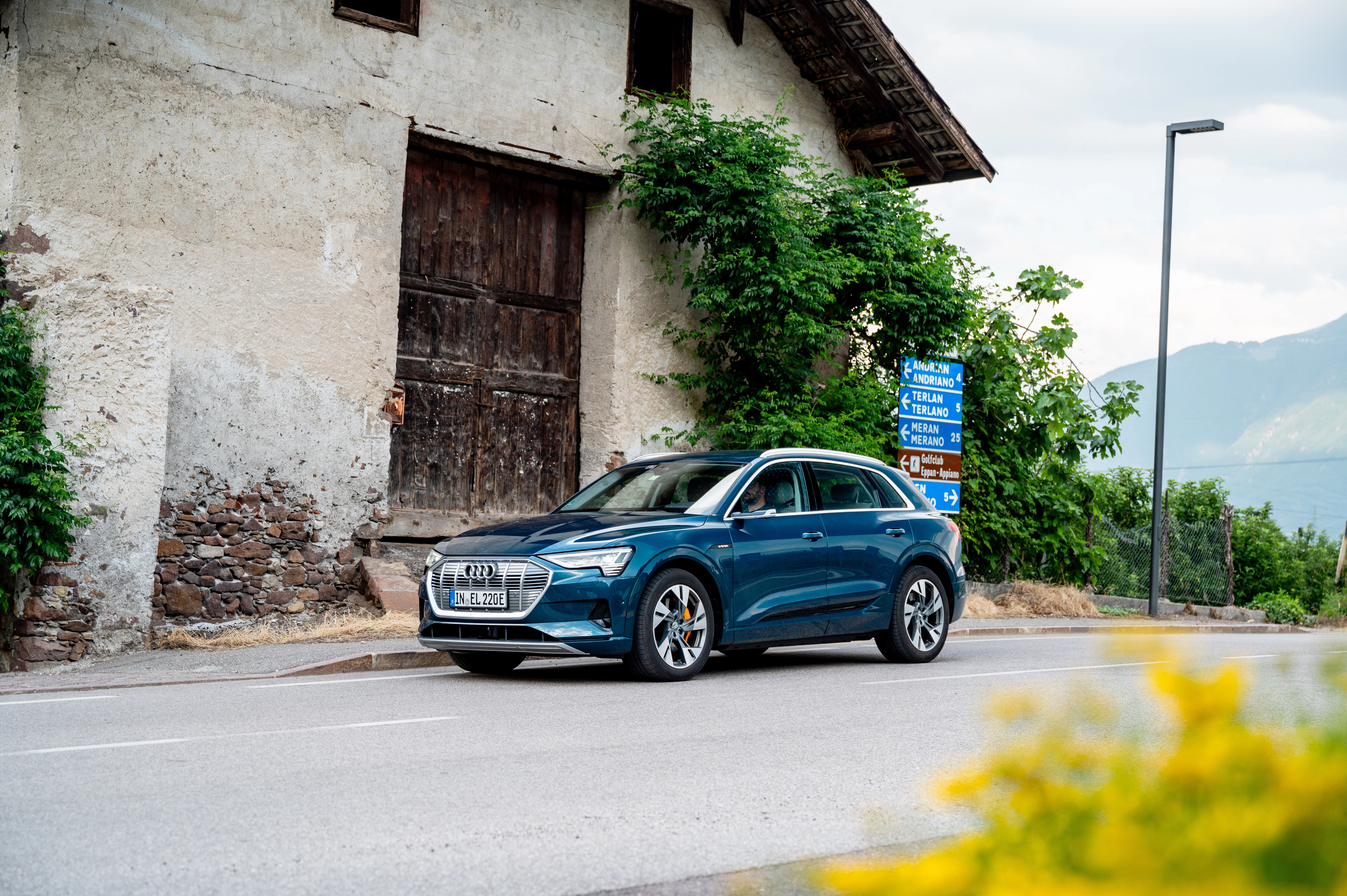 Blauer Audi e-tron seitlich vor einer Scheune