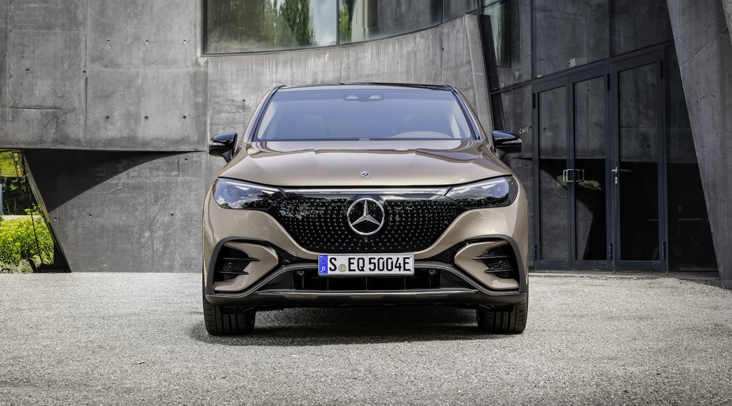 Ein bronzener Mercedes-Benz EQE SUV parkt vor einem Gebäude