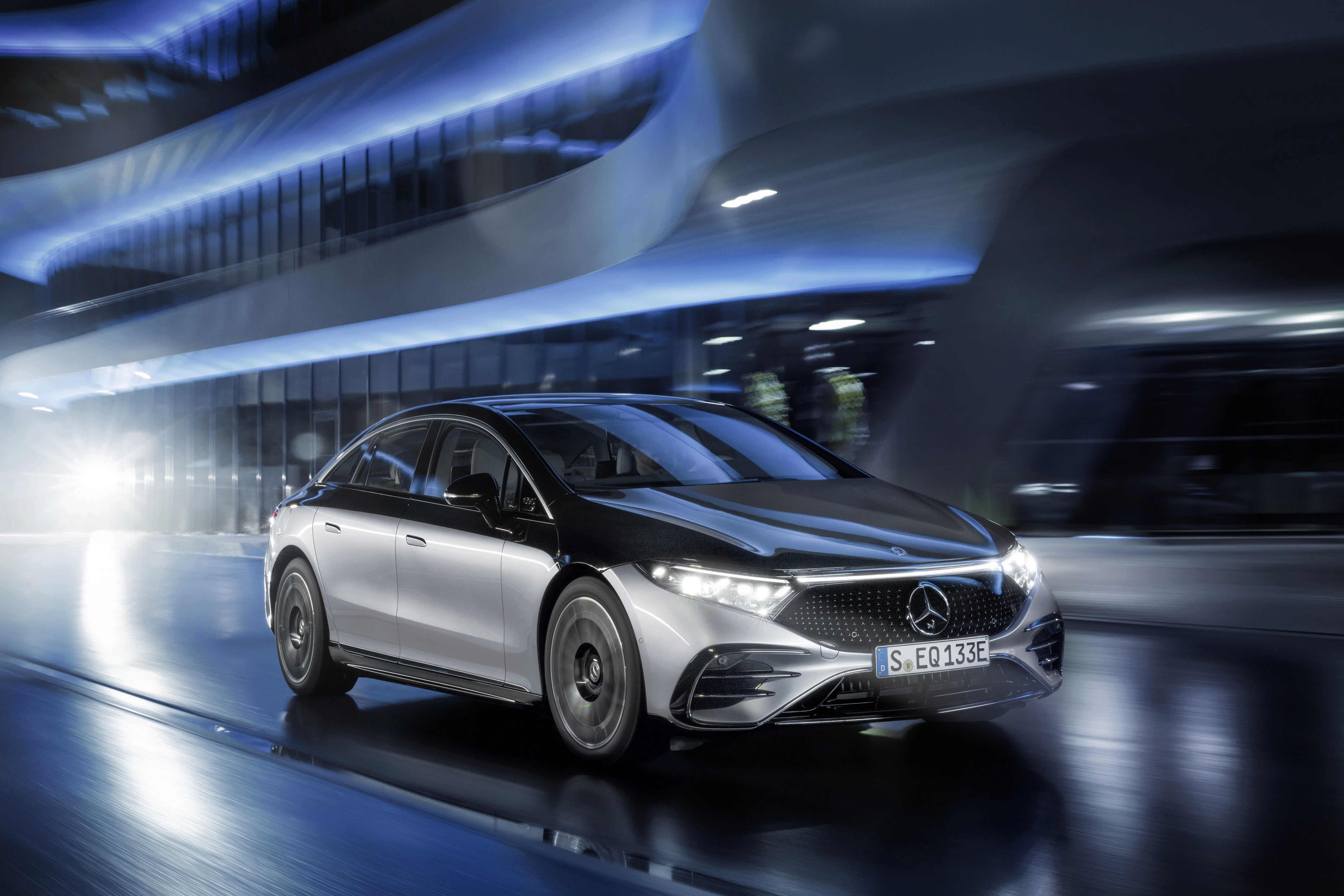 Ein Mercedes-Benz EQS fährt durch eine futurische Szenerie