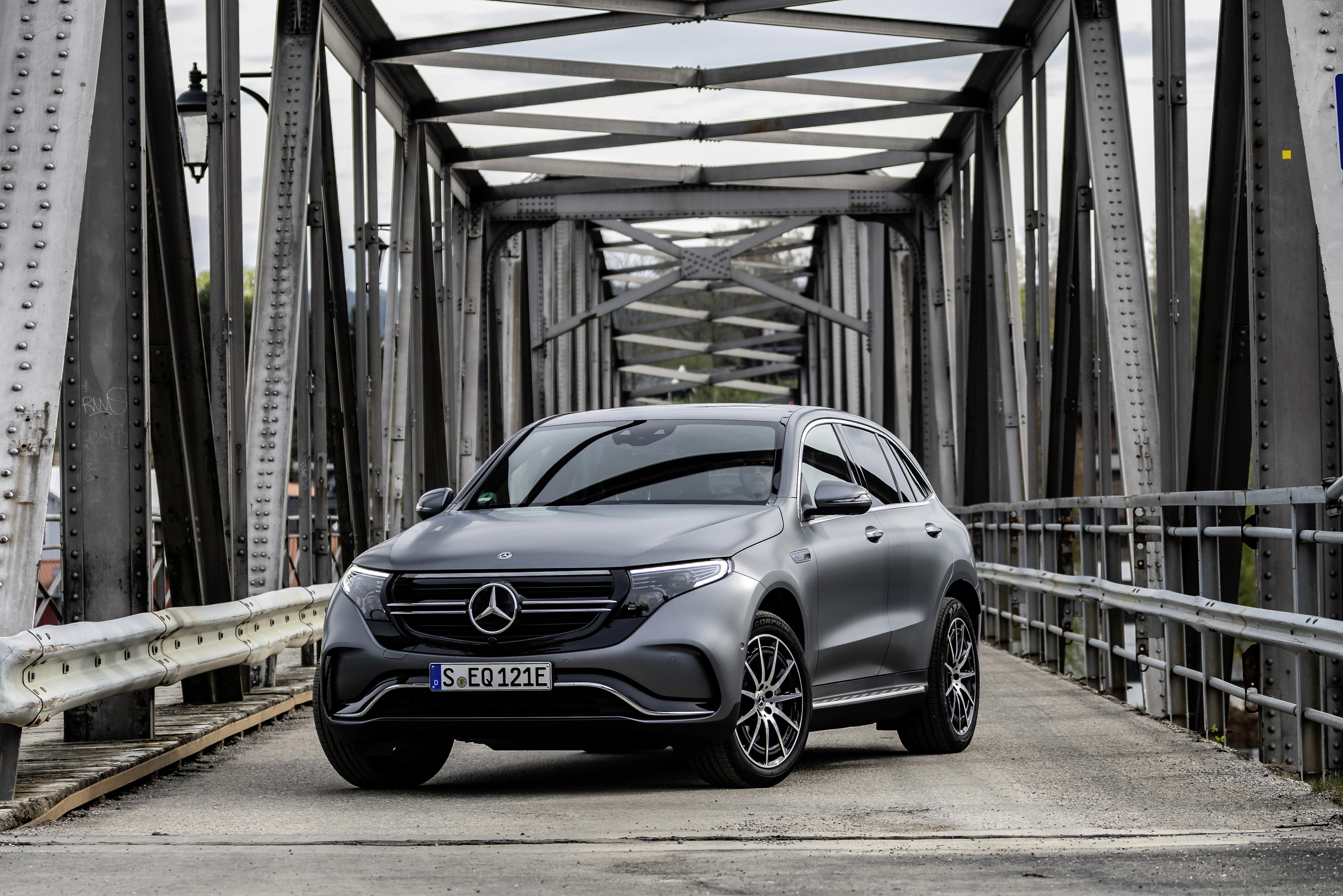 Ein grauer Mercedes-Benz EQC steht auf einer Brücke