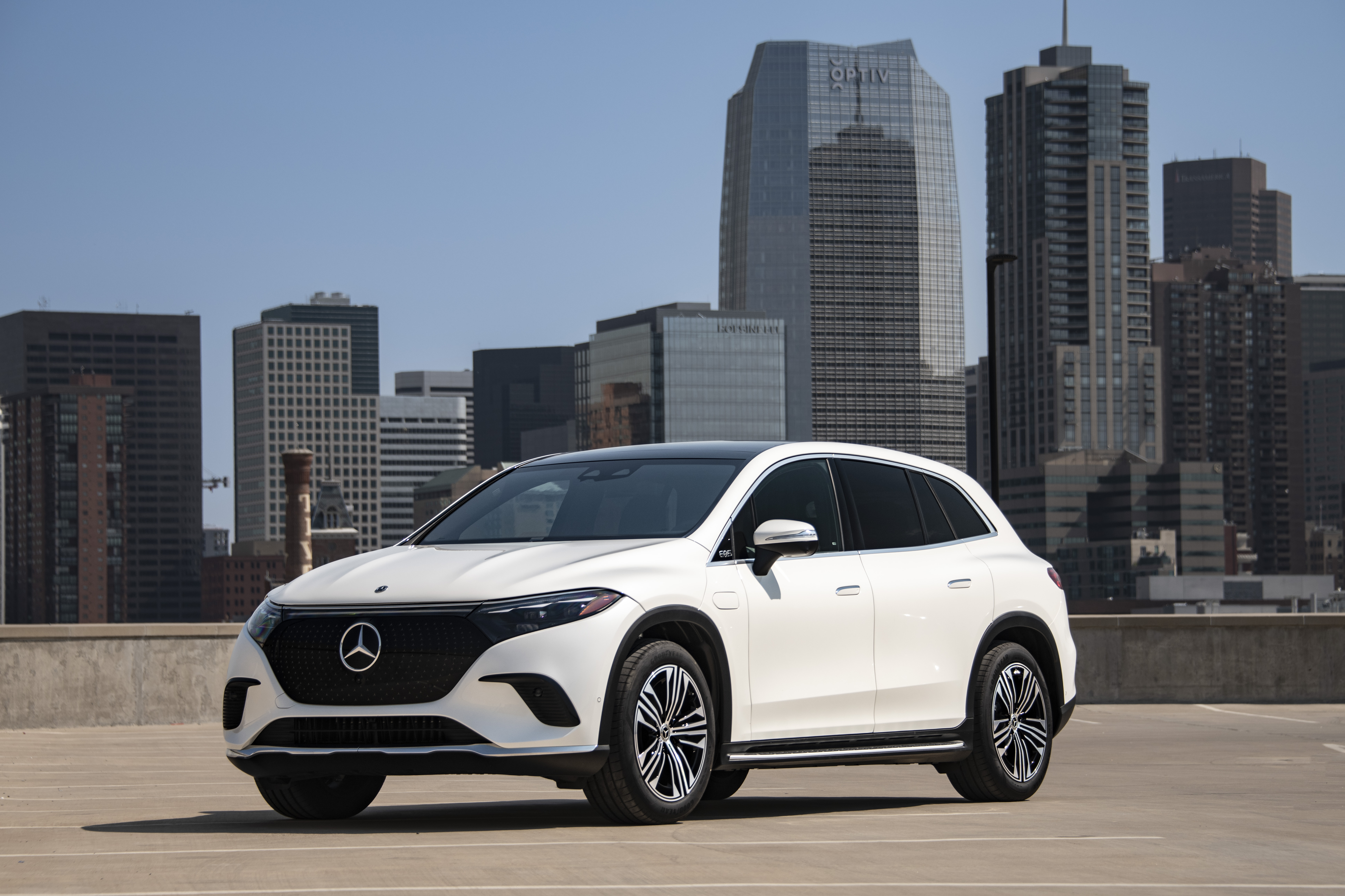 Ein weißer Mercedes-Benz EQS SUV steht vor einer Stadt