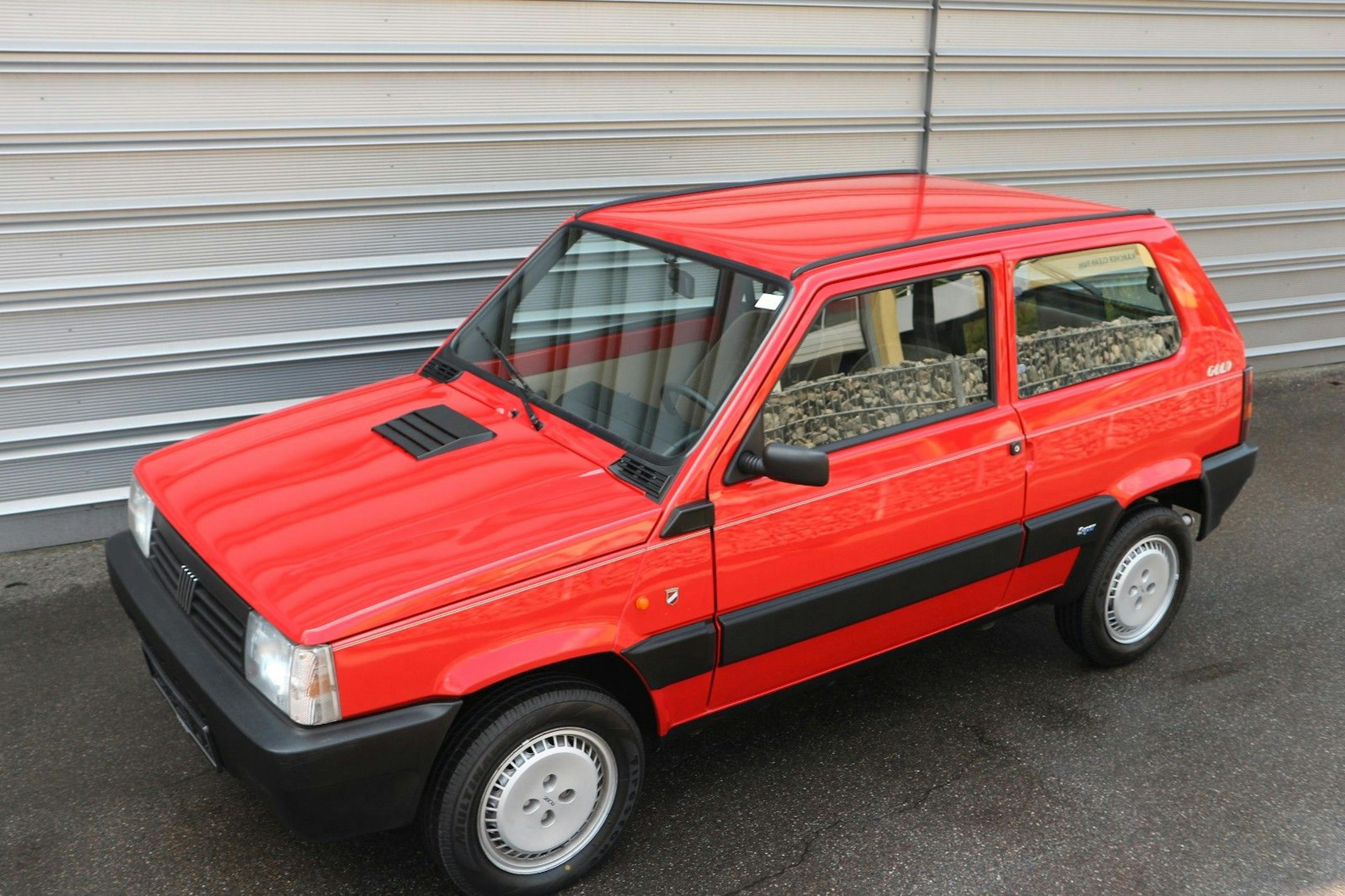 Ein roter Fiat Panda steht vor einem Rolltor.