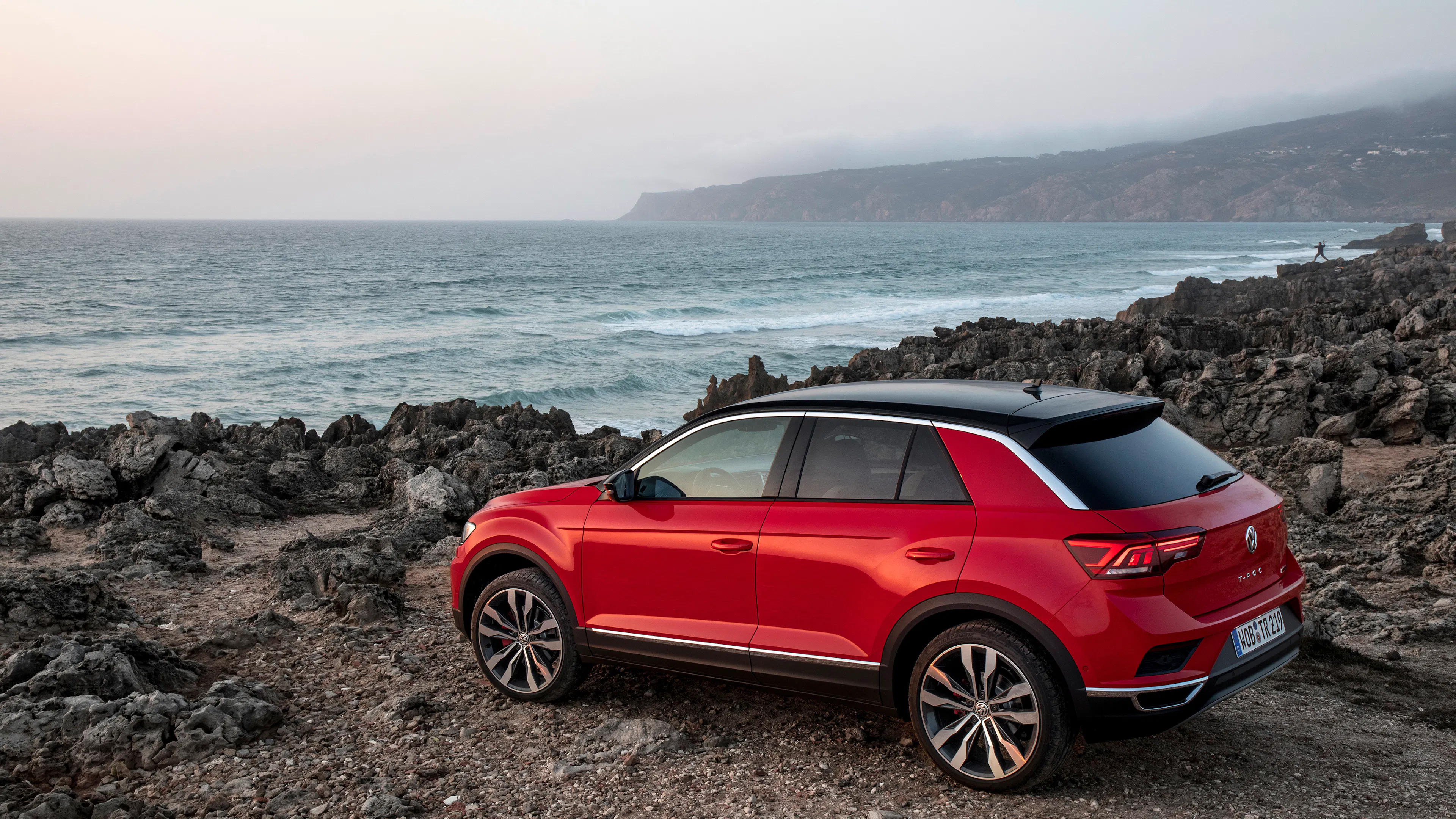 Red VW T-Roc in side view, standing.