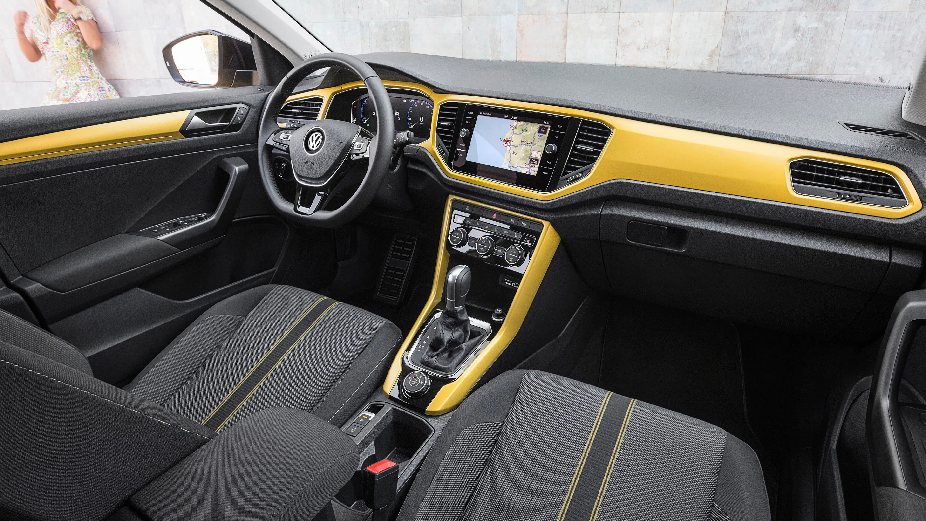 Interior of a yellow VW T-Roc, view of the dashboard and steering wheel.