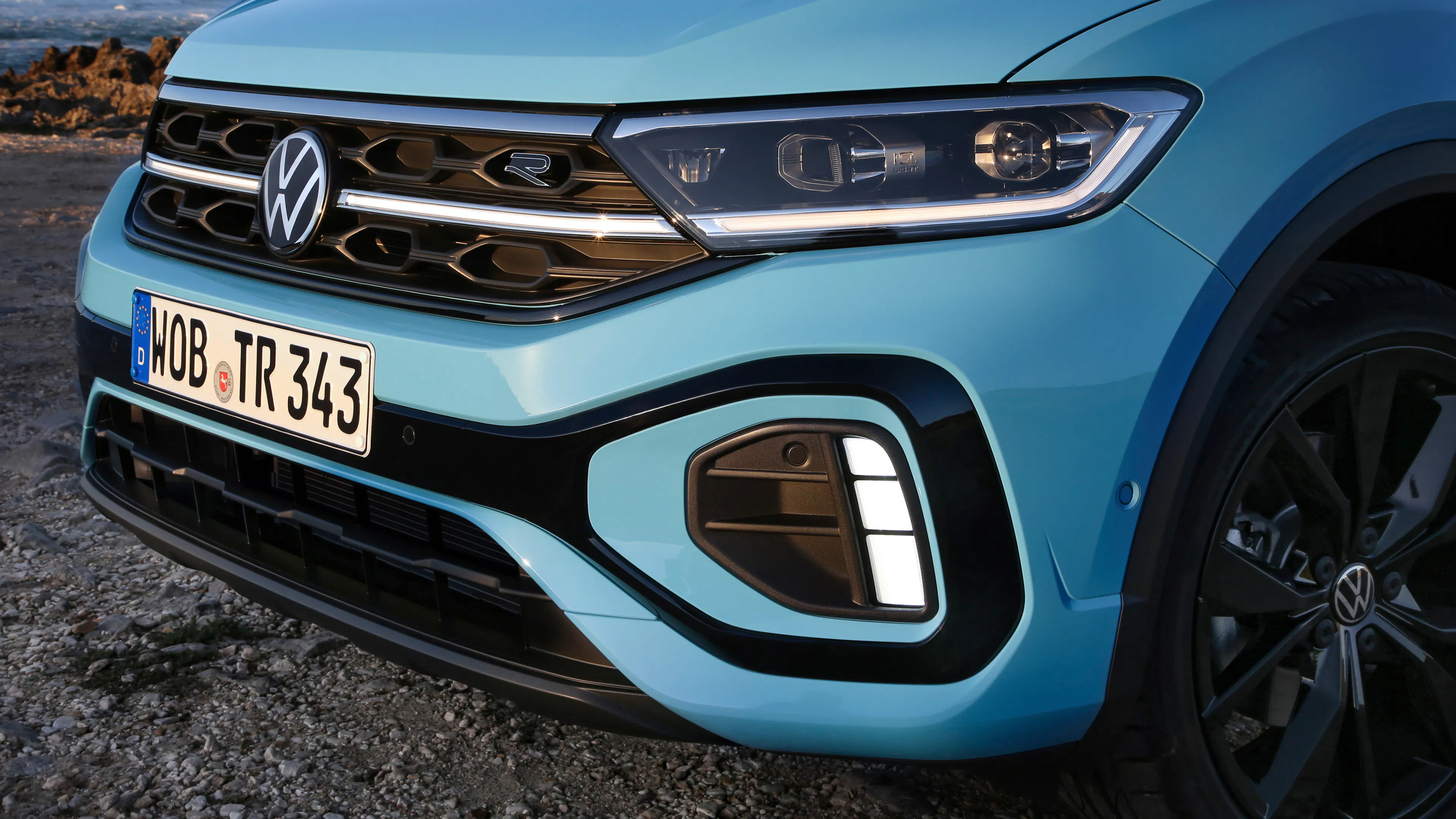 Alt text: The front of a blue VW T-Roc, statically photographed.